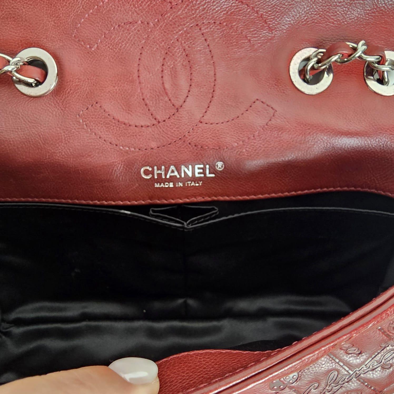 Sac moyen à rabat en cuir bordeaux embossé du porte-bonheur de Chanel. Très bon état général. Petites éraflures sur le cuir et les coins. Série n°14. Livré avec sa carte et son holo.
