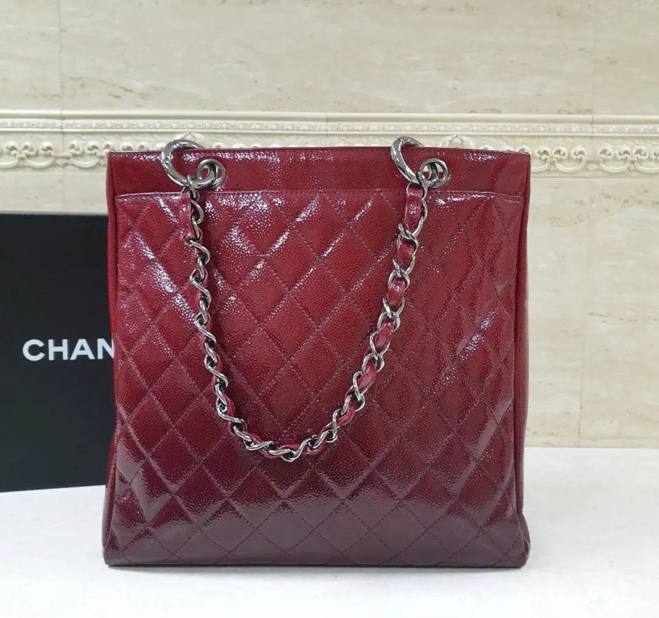 With dual interwoven chain-leather handles, this Chanel 2.55 Reissue bag will offer you an easy carrying experience. Made from burgundy ombré patent grained leather in a quilted pattern, it flaunts gunmetal-tone hardware and a turn-lock on the