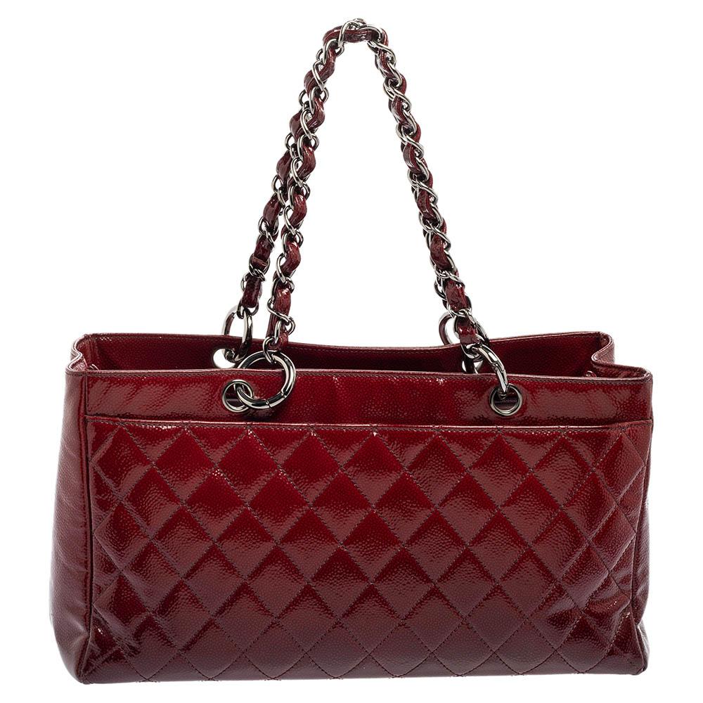 With dual interwoven chain-leather handles, this Chanel 2.55 Reissue bag will offer you an easy carrying experience. Made from burgundy ombré patent leather in a quilted pattern, it flaunts gunmetal-tone hardware and a turn-lock on the front. The