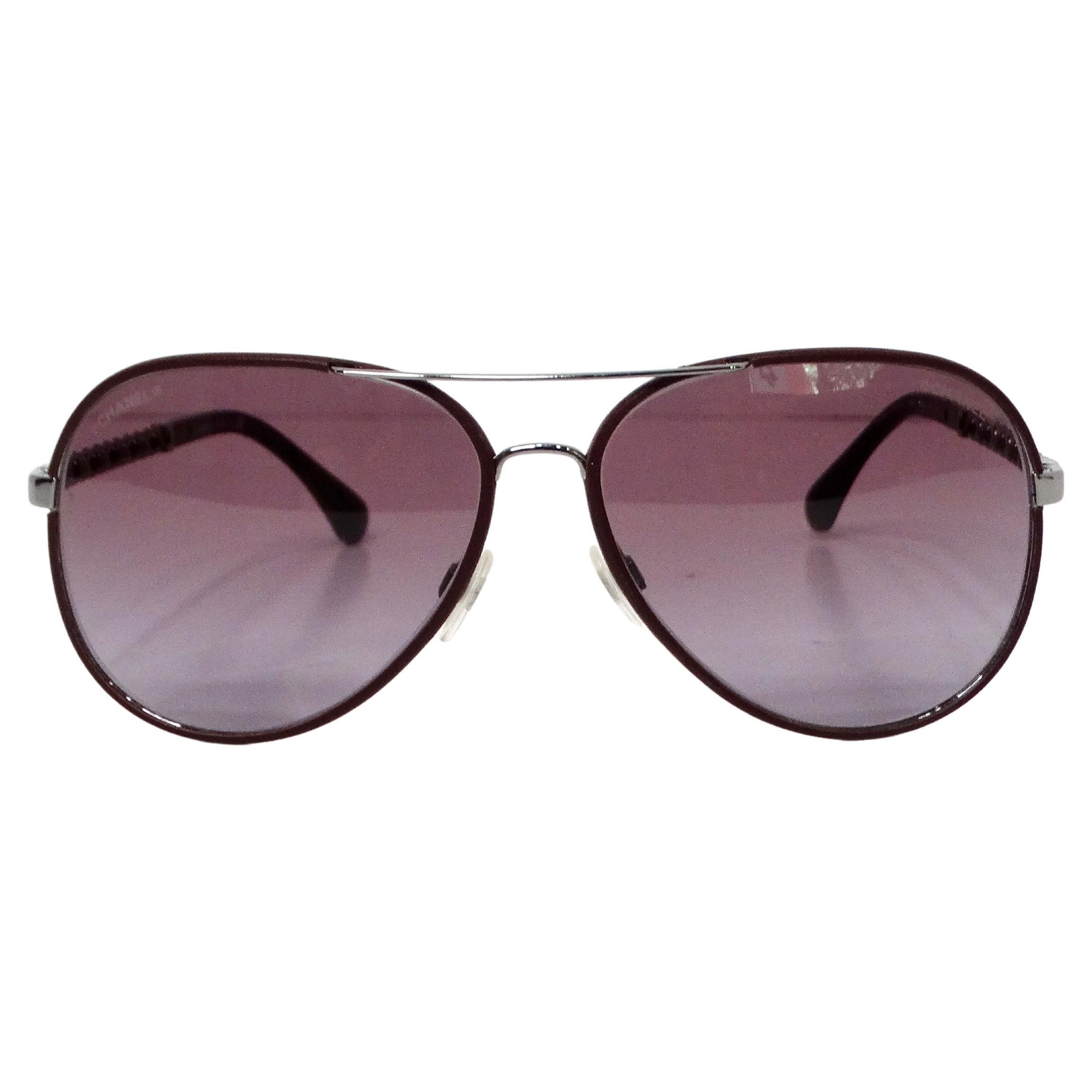 The Chanel Burgundy Pilot Aviator Sunglasses with Chain-Link Leather Detailing embody timeless sophistication and modern elegance. Crafted with a rich burgundy hue, these sunglasses feature iconic aviator frames that exude confidence and style. The