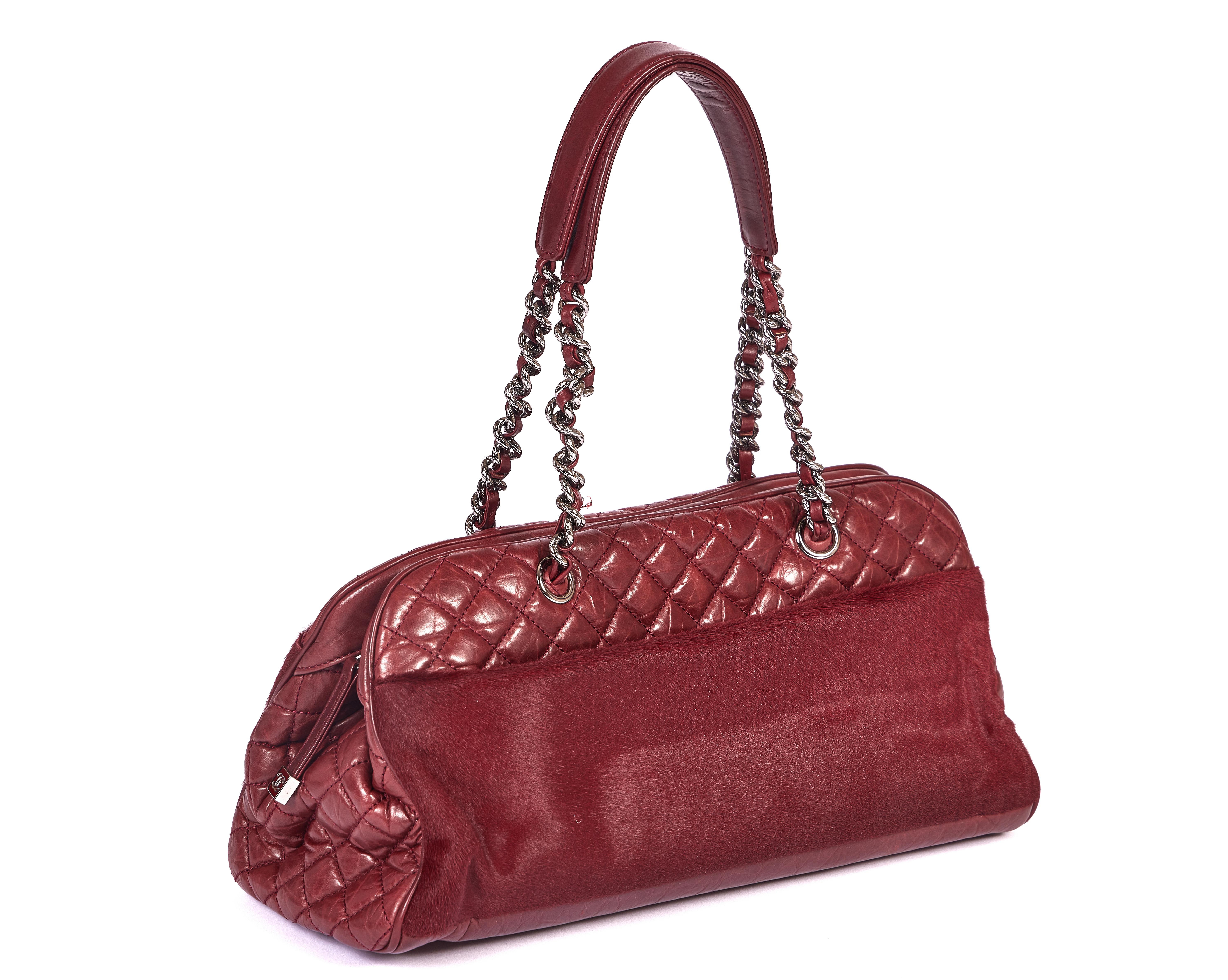 Ce sac Chanel bordeaux de 2006 est fabriqué en cuir et fini avec du poil de poney. Le sac à bandoulière est livré avec les chaînes classiques et la chute est de 8 pouces. Il a l'hologramme original et est livré avec un sac à poussière Chanel.
