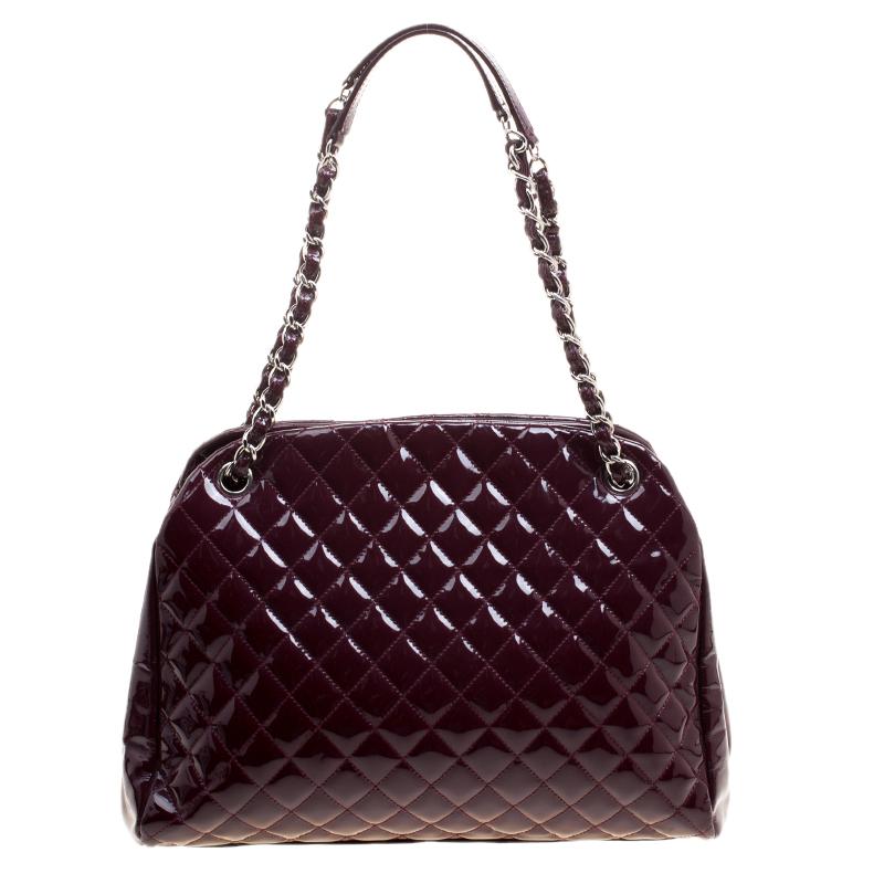 Spacious and captivating, this Just Mademoiselle Bowling bag is from Chanel. It has been crafted from aged leather in their signature quilt pattern and accented with silver tone hardware. It is equipped with two chain handles and a top zipper that