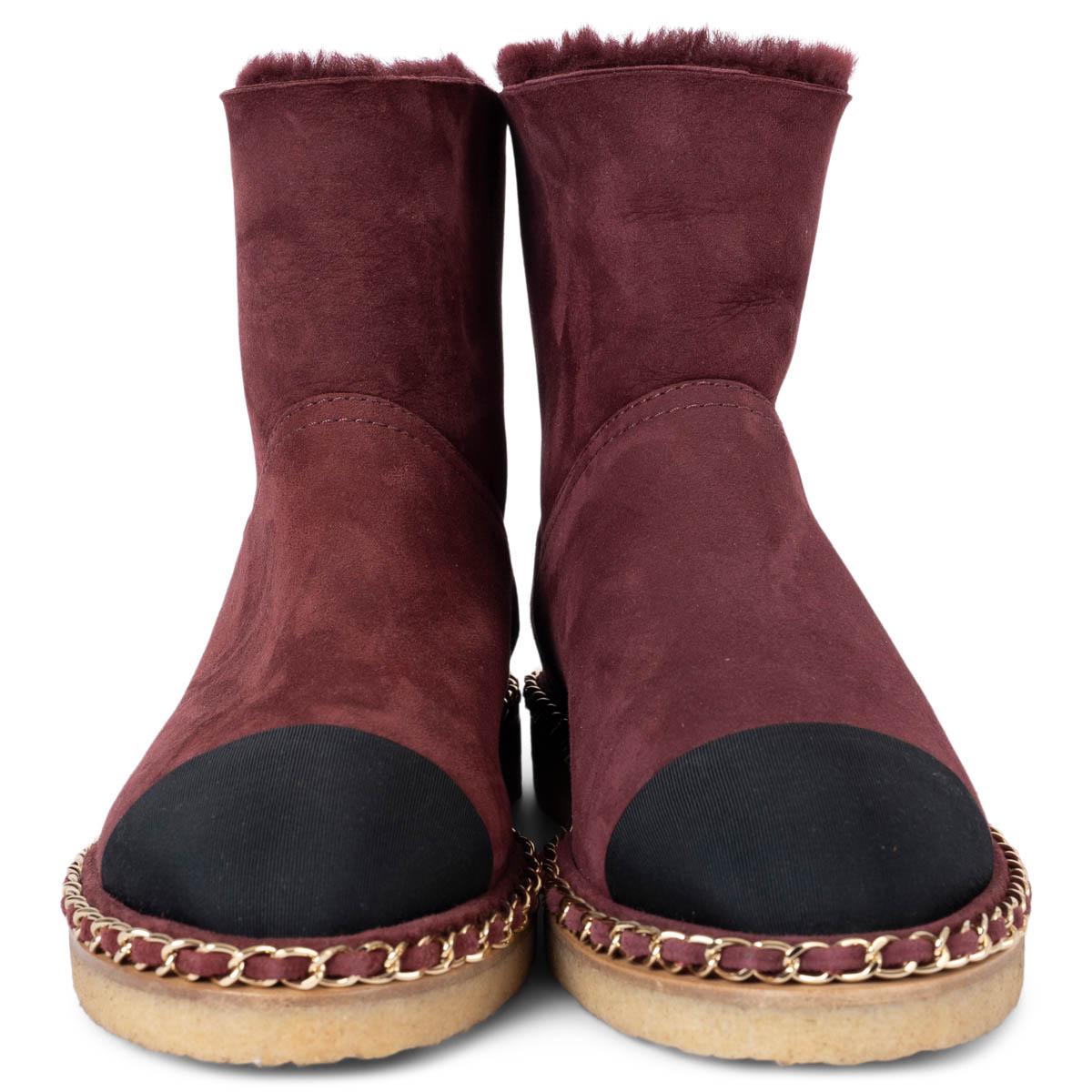 100% authentic Chanel shearling lined boots in burgundy suede featuring classic black grosgrain cap toe, bordered with a gold-tone chain and beige crepe sole. Have been worn once inside and are in virtually new condition. 

2019