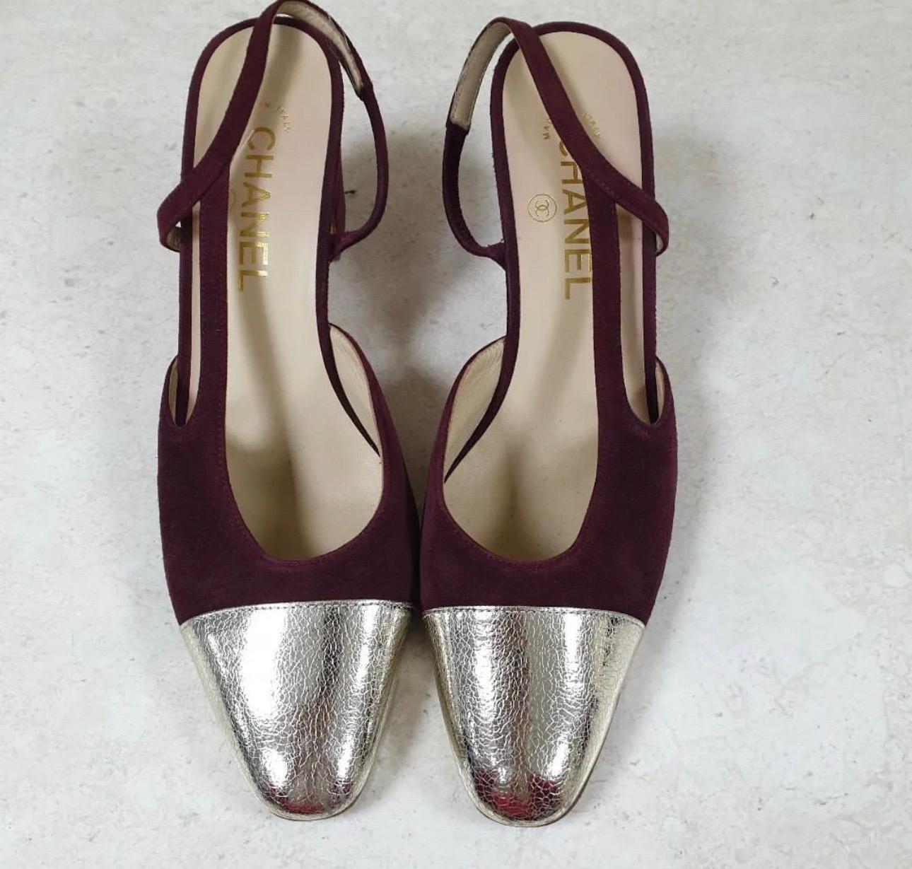 Bring Chanel's chic aesthetics and flawless skill to your collection with these beautiful sandals. 
They have been designed using burgundy suede and metallic-silver leather on the exterior and feature cap toes and a slingback. 
For a classy touch,