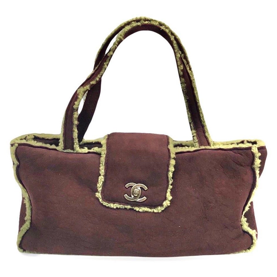 - Chanel burgundy suede shearling shoulder handbag from 1998 collection. 

- Featuring burgundy shearling mouton trim overall. 

- CC turnlock flap closure. 

- Interior zip pocket. 

- Length: 32cm. Height: 16cm. Width: 7.5cm. Handle Drop: 18cm