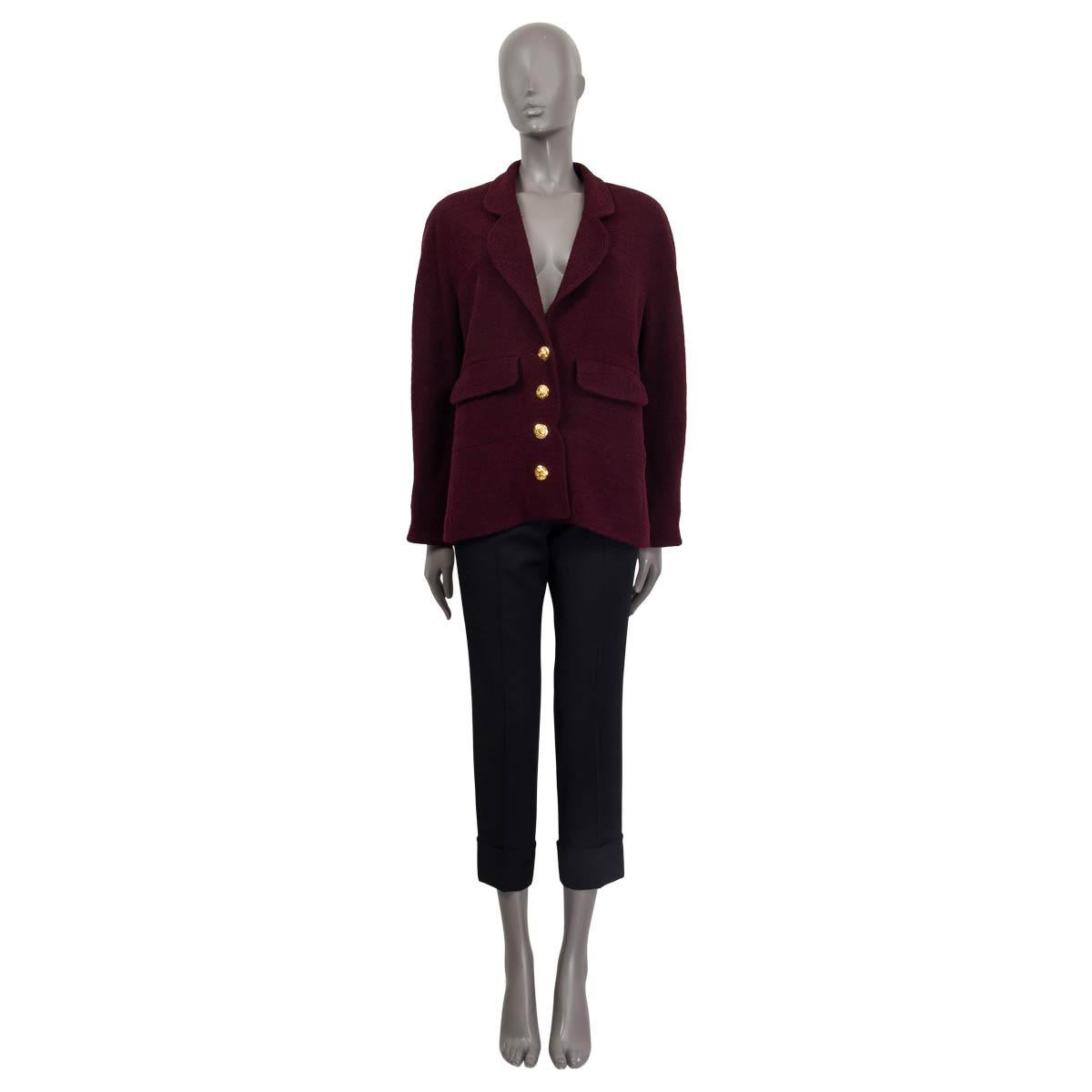 100% authentic Chanel tweed blazer in burgundy wool (assumed cause tag is missing). Features raglan sleeves (sleeve measurements taken from the neck) and two front flap pockets. Opens with four golden 'CC' buttons on the front. Lined in burgundy