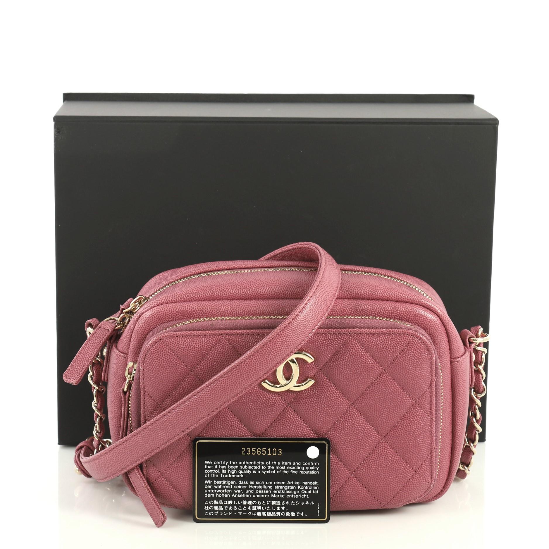 This Chanel Business Affinity Camera Case Bag Quilted Caviar Small, crafted in pink quilted caviar leather, features woven-in leather chain strap with leather pad, exterior front zip pocket, CC logo at front and gold-tone hardware. Its zip closure