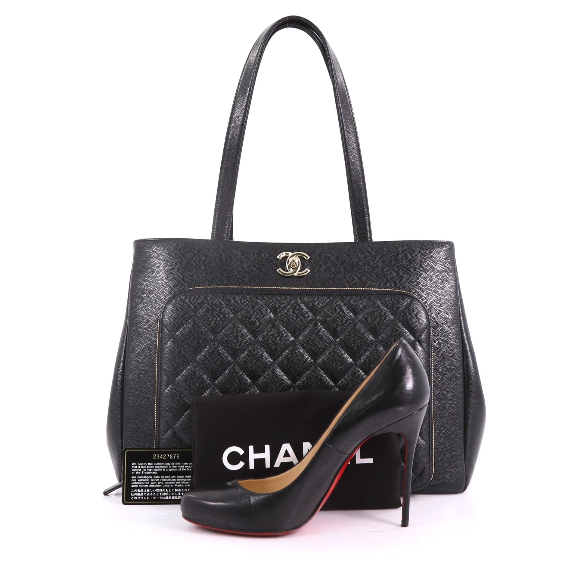 This Chanel Business Affinity Tote Quilted Caviar Large, crafted from black quilted caviar, features dual flat leather handles, front zip pocket, and gold-tone hardware. Its turn-lock closure opens to a burgundy leather interior with zip and slip