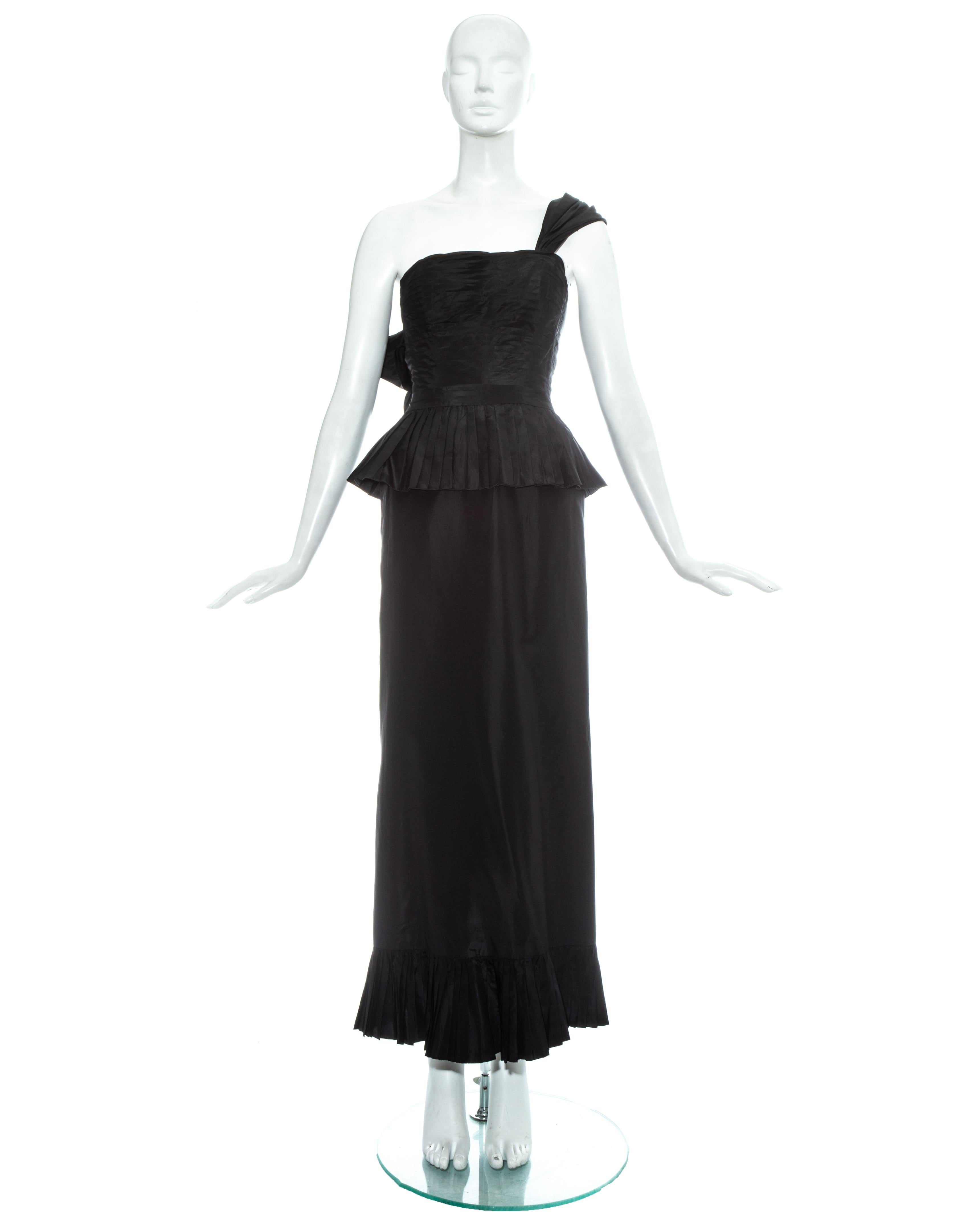 Chanel by Karl Lagerfeld; black silk taffeta evening dress. Bustier with horizontal pleats, internal boing, box pleated peplum and draped shoulder strap with decorative bow fastening. Maxi skirt with box pleated trim, back vent with decorative bow