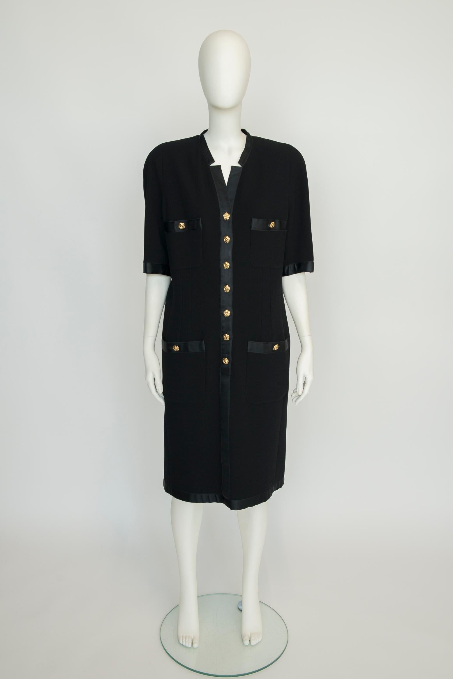 So very Chanel ! Made from black wool, this 1990-1991 Fall-Winter Chanel by Karl Lagerfeld shift dress is designed for a roomy fit. Contrasting black silk satin ribbon is to be found along the front buttons closure, the four large patch pockets