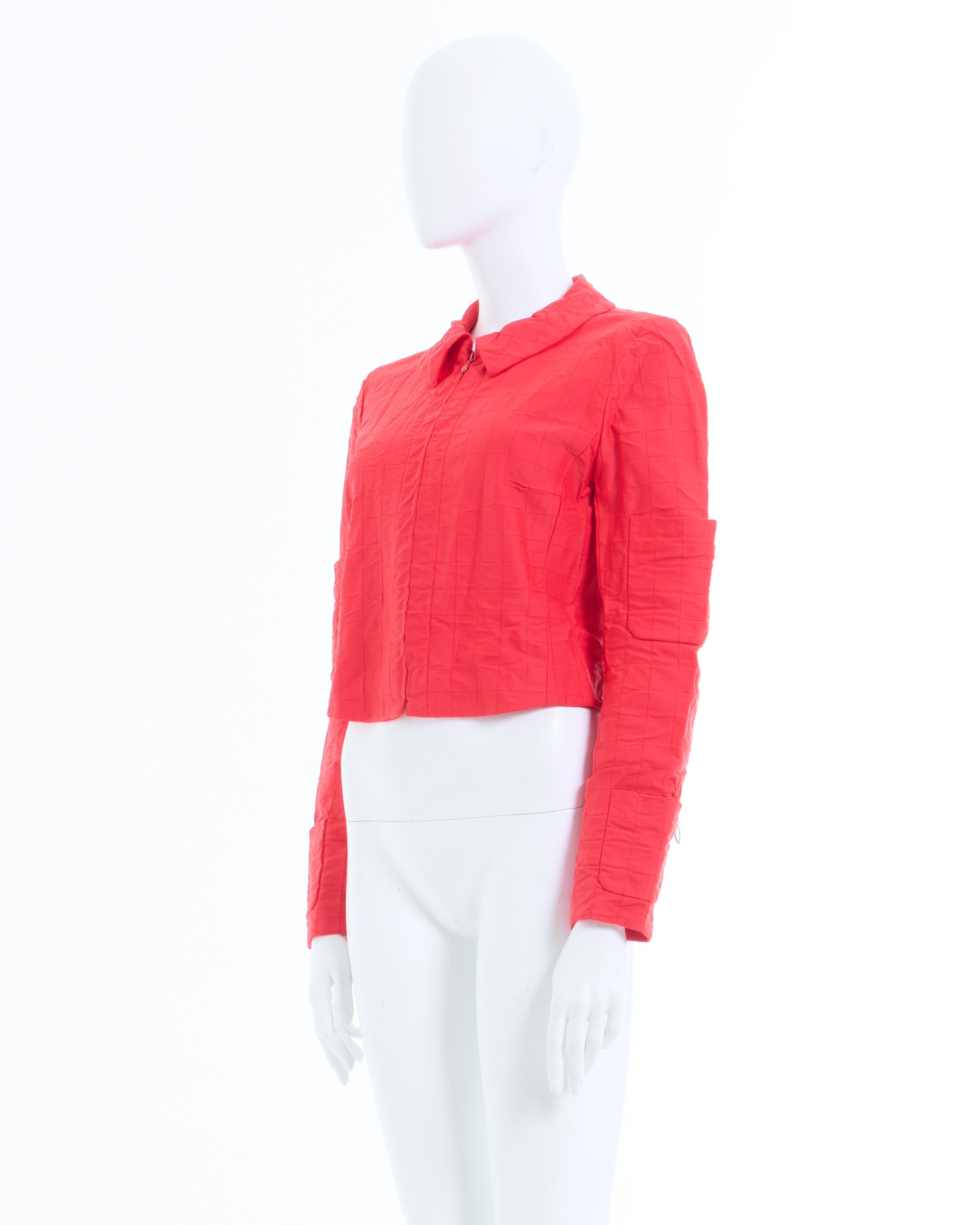 - Chaqueta de nailon acolchada roja de Chanel 
- Vendido por Skof.Archive 
- Diseñado por Karl Lagerfeld 
- Colección Cruise 2000 
- Chaqueta roja con forro de seda 
- Tejido elástico 
- Cuello clásico 
- Cierre frontal con cremallera 
- Cuatro