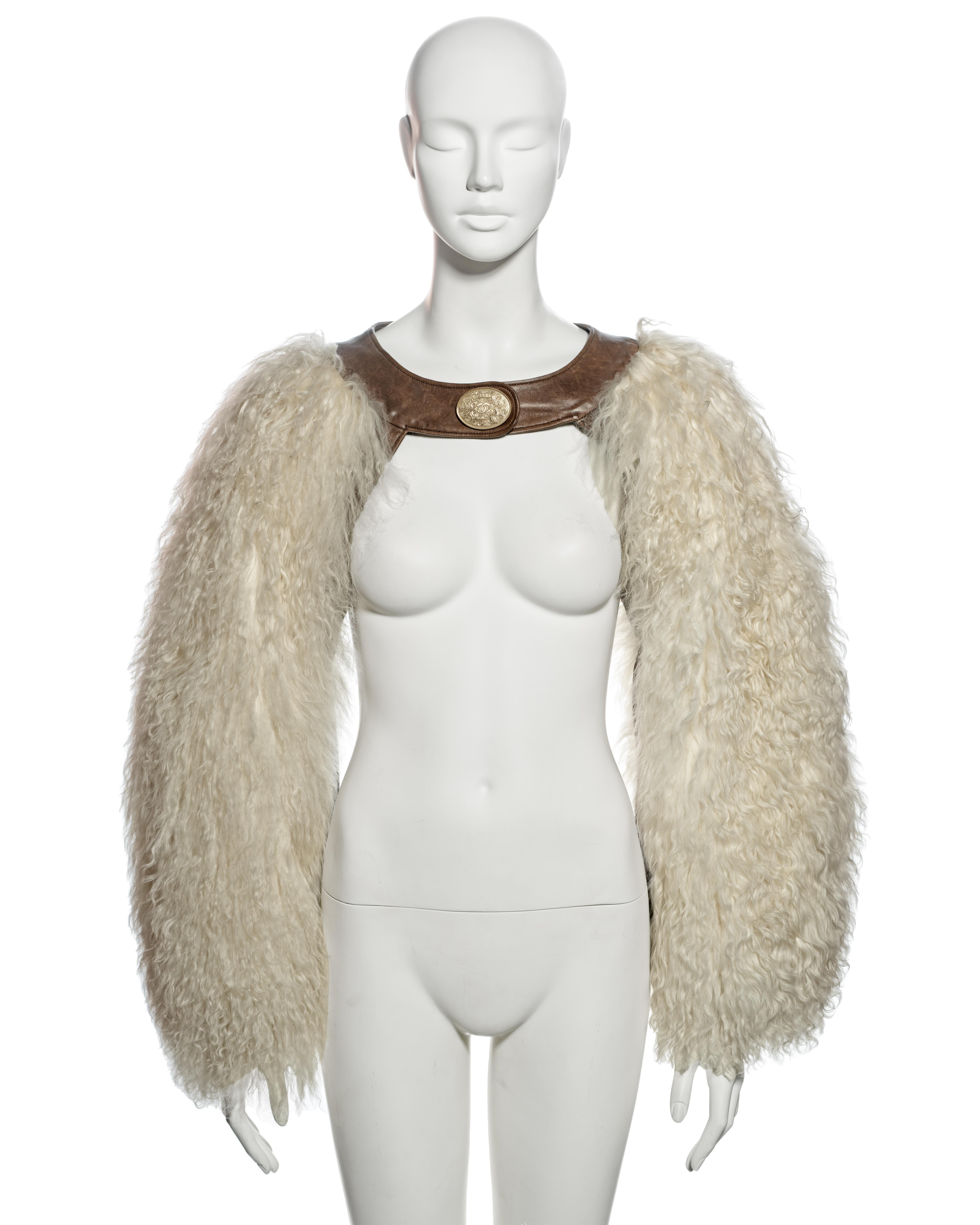 ▪ Archival Chanel Shearling Sleeves
▪ Creative Director: Karl Lagerfeld
▪ Métiers d'Art collection: Back in Dallas, pf 2014
▪ Sold by One of a Kind Archive
▪ Oversized White shearling sleeves 
▪ Connected with a brown lambskin leather collar 
▪