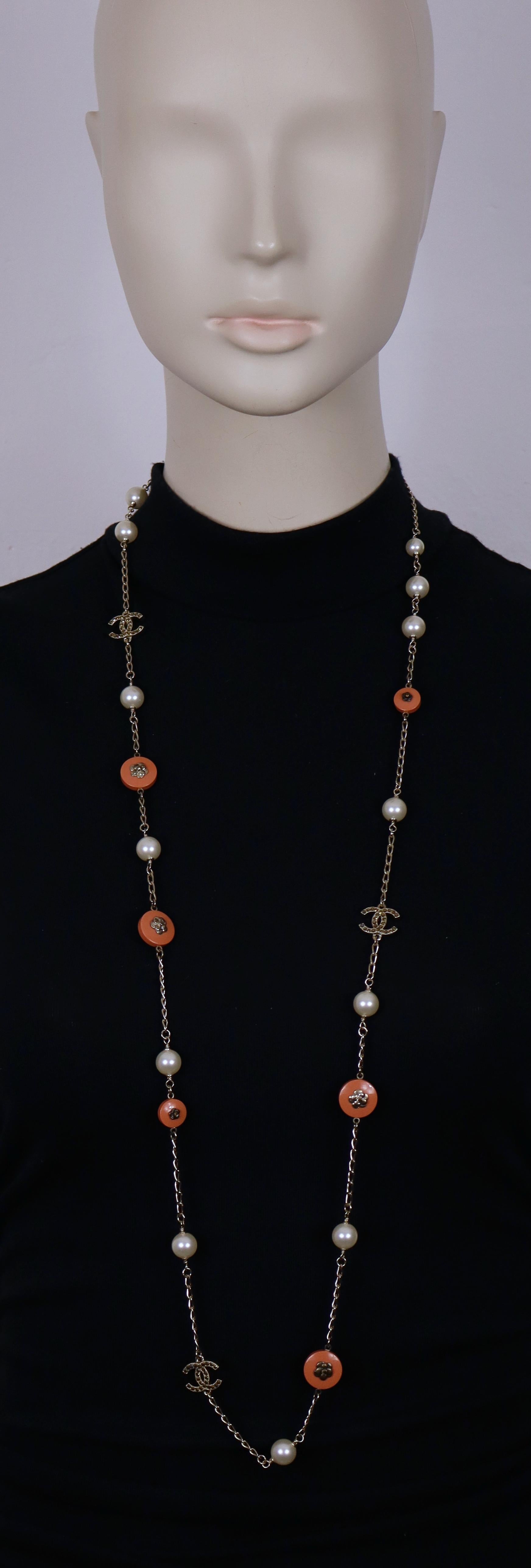 Collar CHANEL by KARL LAGERFELD en tono dorado pálido con logotipos CC enjoyados, perlas de imitación y camelias (tonos envejecidos, del tono dorado envejecido al tono bronce) sobre botones de resina.

Cierre de langosta.

Grabado CHANEL 11 P