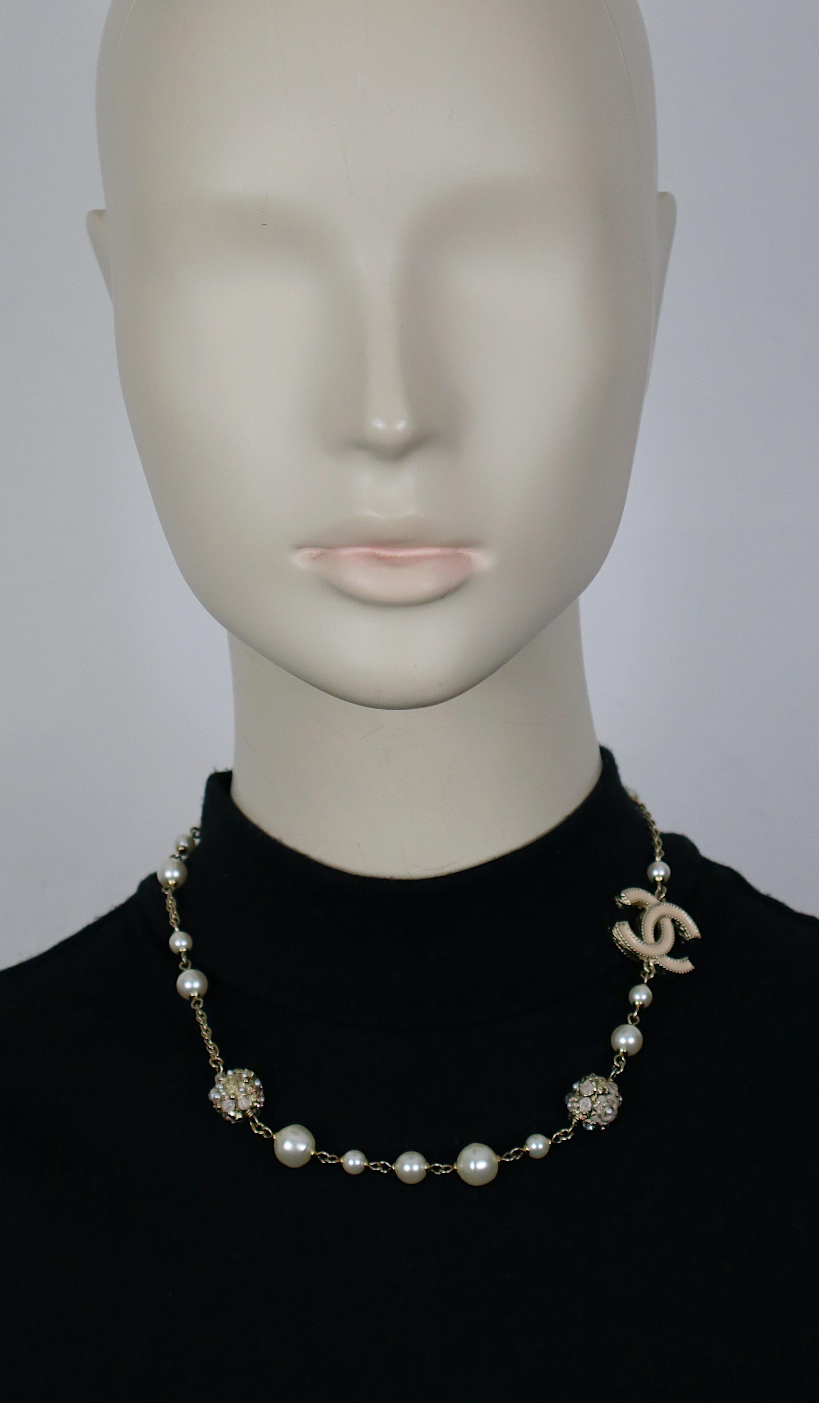 CHANEL by KARL LAGERFELD pale gold tone necklace featuring an enameled CC logo, faux pearls, two jeweled beads with camellia and CC.

Lobster clasp closure.

Embossed CHANEL A11 A Made in France.

Indicative measurements : length from approx. 43.5