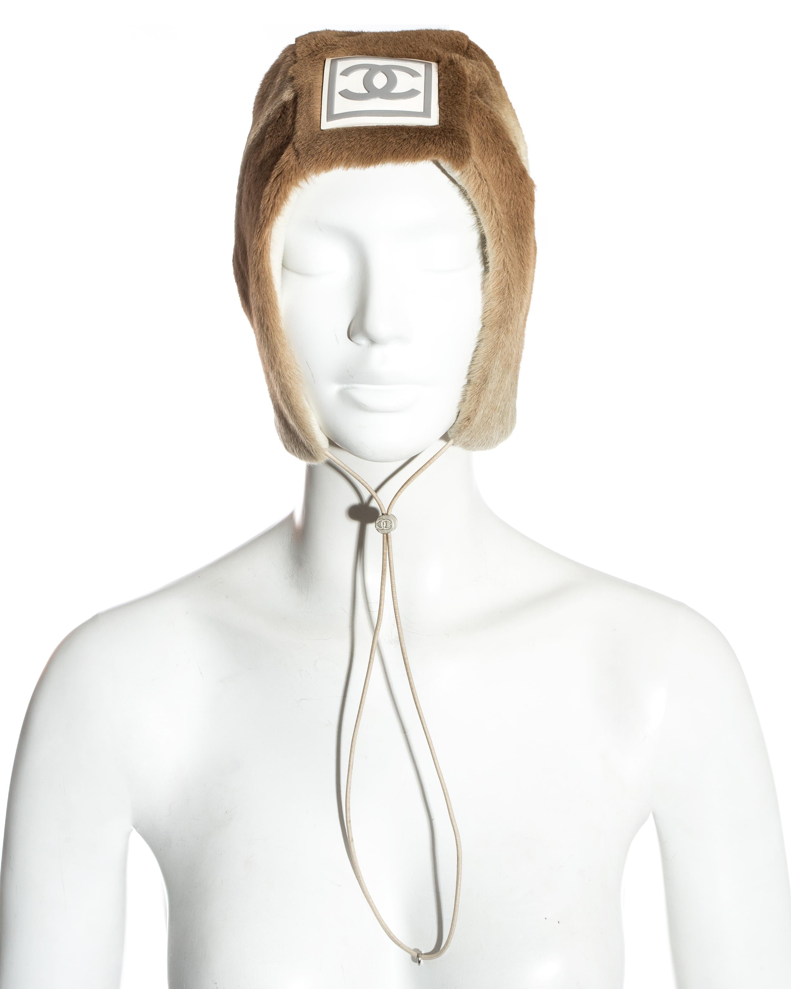 Chanel by Karl Lagerfeld; fawn sheared fur trapper hat. Large rubber interlocking C logo at the front, silver  toggle drawstring fastening, cream fleece lining. 

Fall-Winter 2001