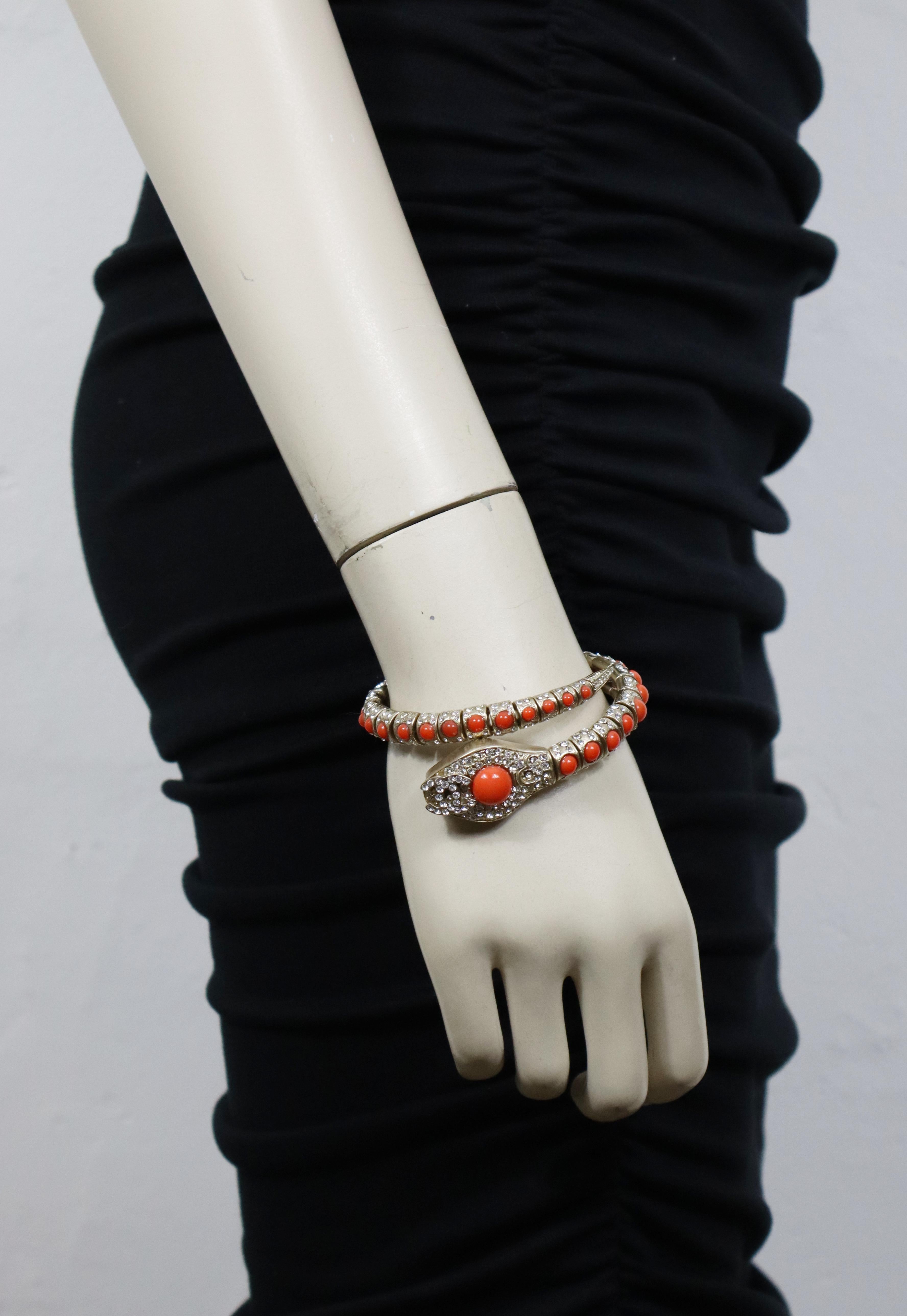 CHANEL by KARL LAGERFELD pale gold tone coil snake bracelet embellished with faux coral glass cabochons and clear crystals, featuring a jewelled CC on the snake head.

This bracelet slips on to the wrist and has room for expansion.

Resort