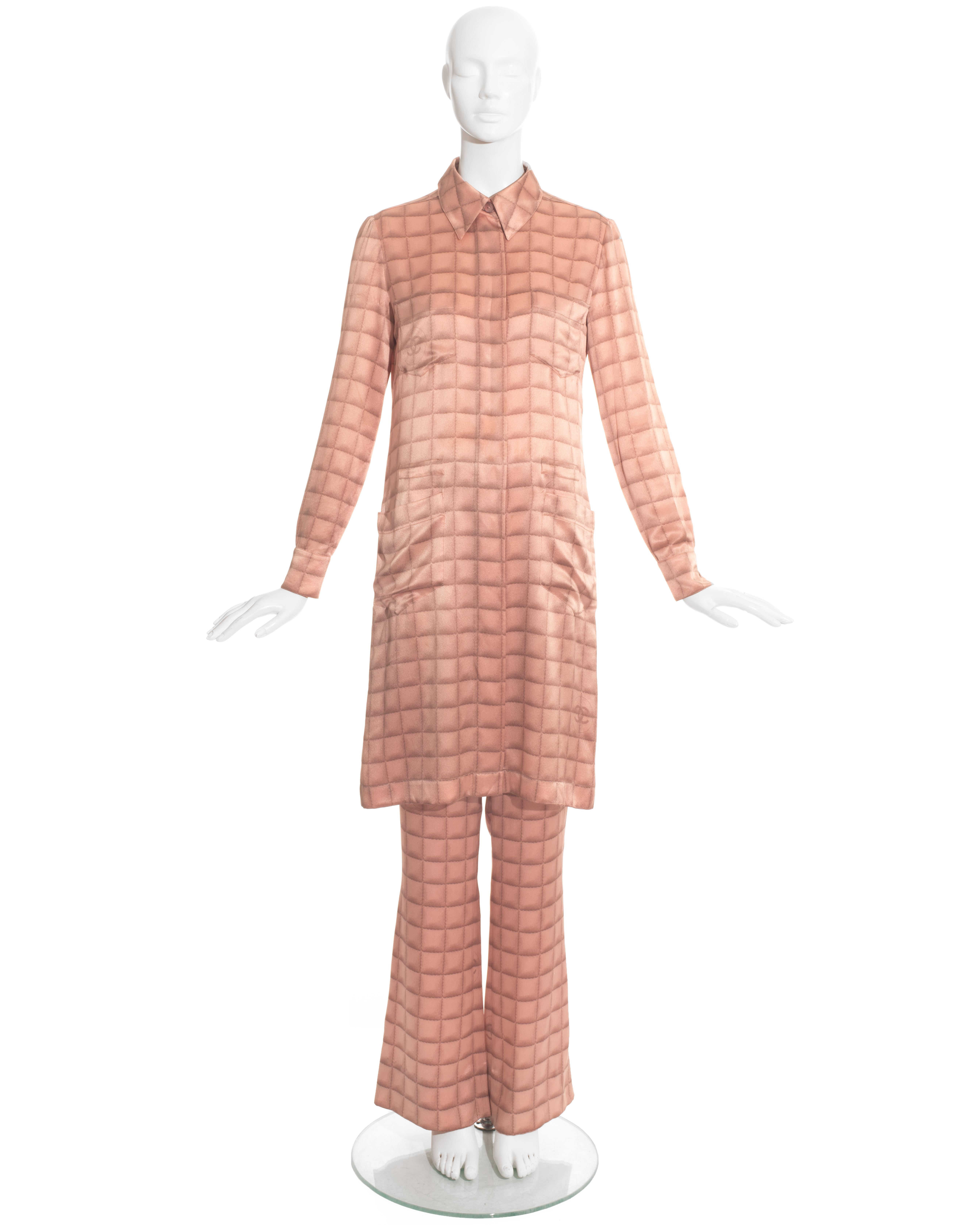 Chanel by Karl Lagerfeld; pink silk with trompe-l'oeil quilt print pant suit comprising: three-quarter length button-up blouse/dress with four open pockets, matching bell bottom pants with zip fastening and silver 'cc' on hip.

Fall-Winter 2000