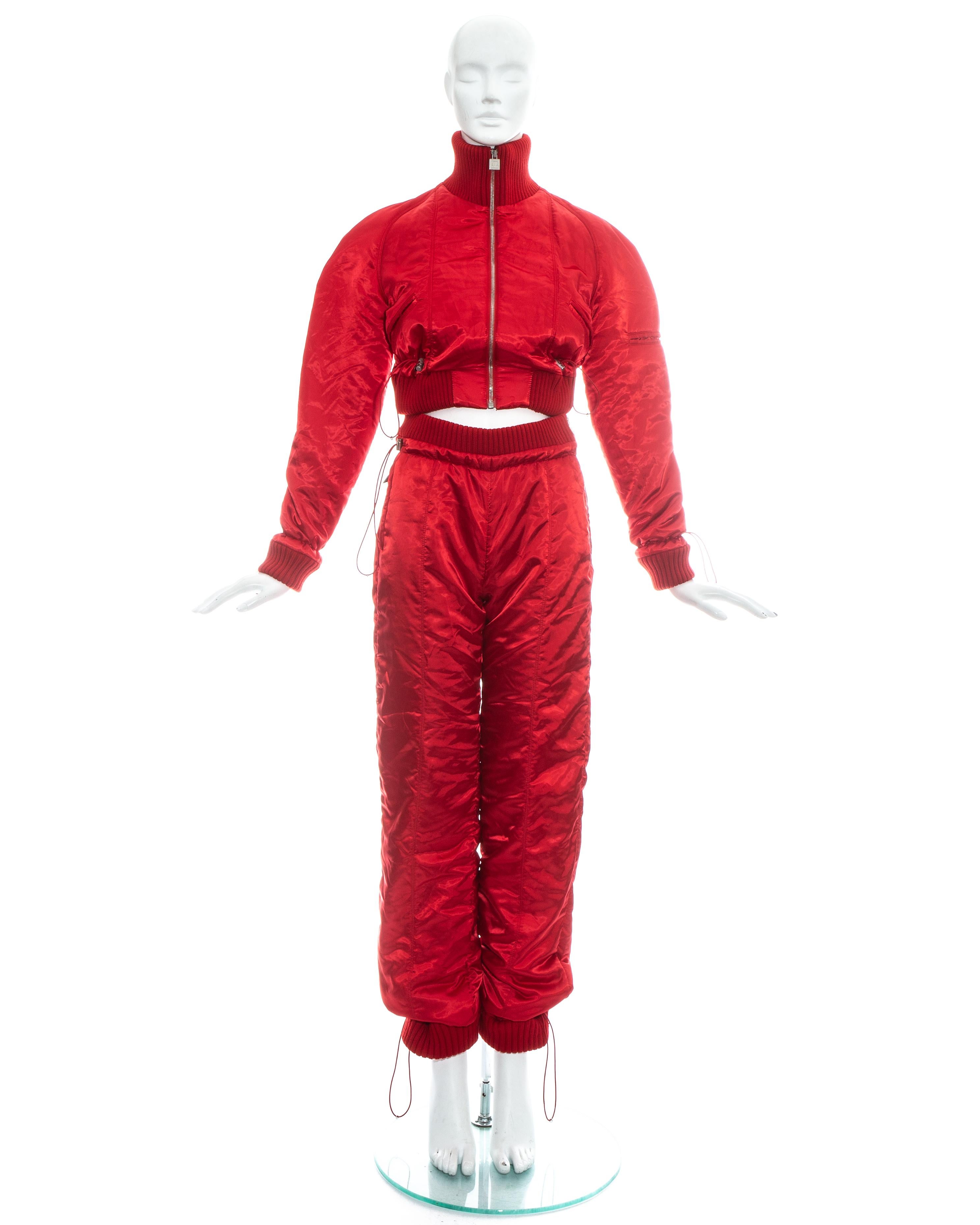 Chanel by Karl Lagerfeld; red polyester tracksuit with ribbed wool. Cropped bomber jacket with turtleneck, zip fastening, two front pockets, one pocket on the sleeve and adjustable drawstring toggles on waistband and wrists. High waisted track pants