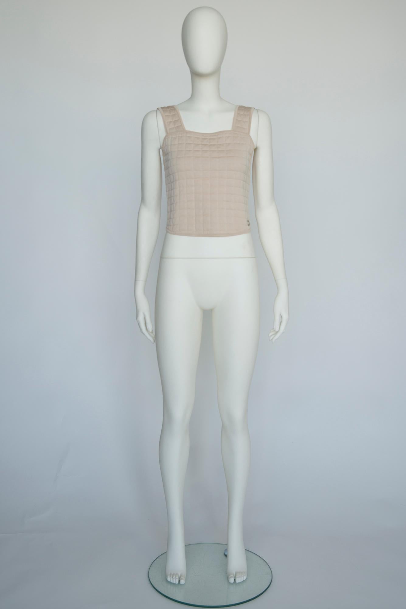 Modeled by Devon Aoki at the Spring-Summer 2000 Chanel runway show in yellow color (see video + pictures 4 & 5), this tank top is designed with quilts for a soft, lightly padded feel. Made from light beige cotton, it has a cropped silhouette,
