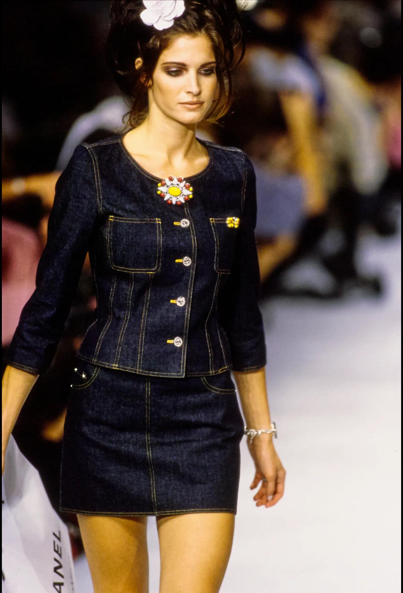 - Chanel setup suit collarless jacket and skirt denim indigo 
- Sold by Skof.Archive
- Designed by Karl Lagerfeld 
- Spring-Summer 1996 
- Collarless jacket with decorative white stitching 
- Metal front buttons closure with CC logo embossed 
- Crop