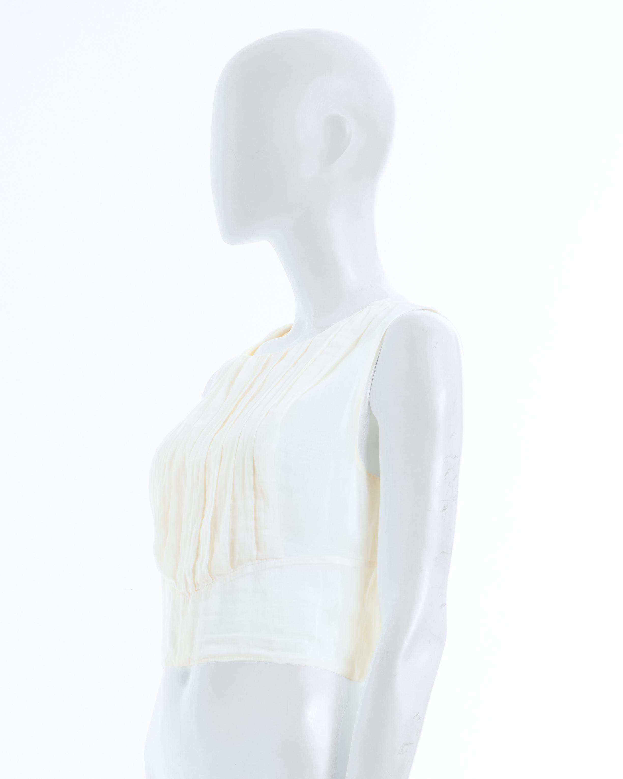 - Chanel off-white silk pleated crop top 
- Designed by Karl Lagerfeld 
- Sold by Skof.Archive
- Spring-Summer 2002 Collection 
- Pleated in front 
- Collarless
- Back CC logo button closure 
- Made in France 
- Size: FR 36 - EN 40 - UK 8 - US 4