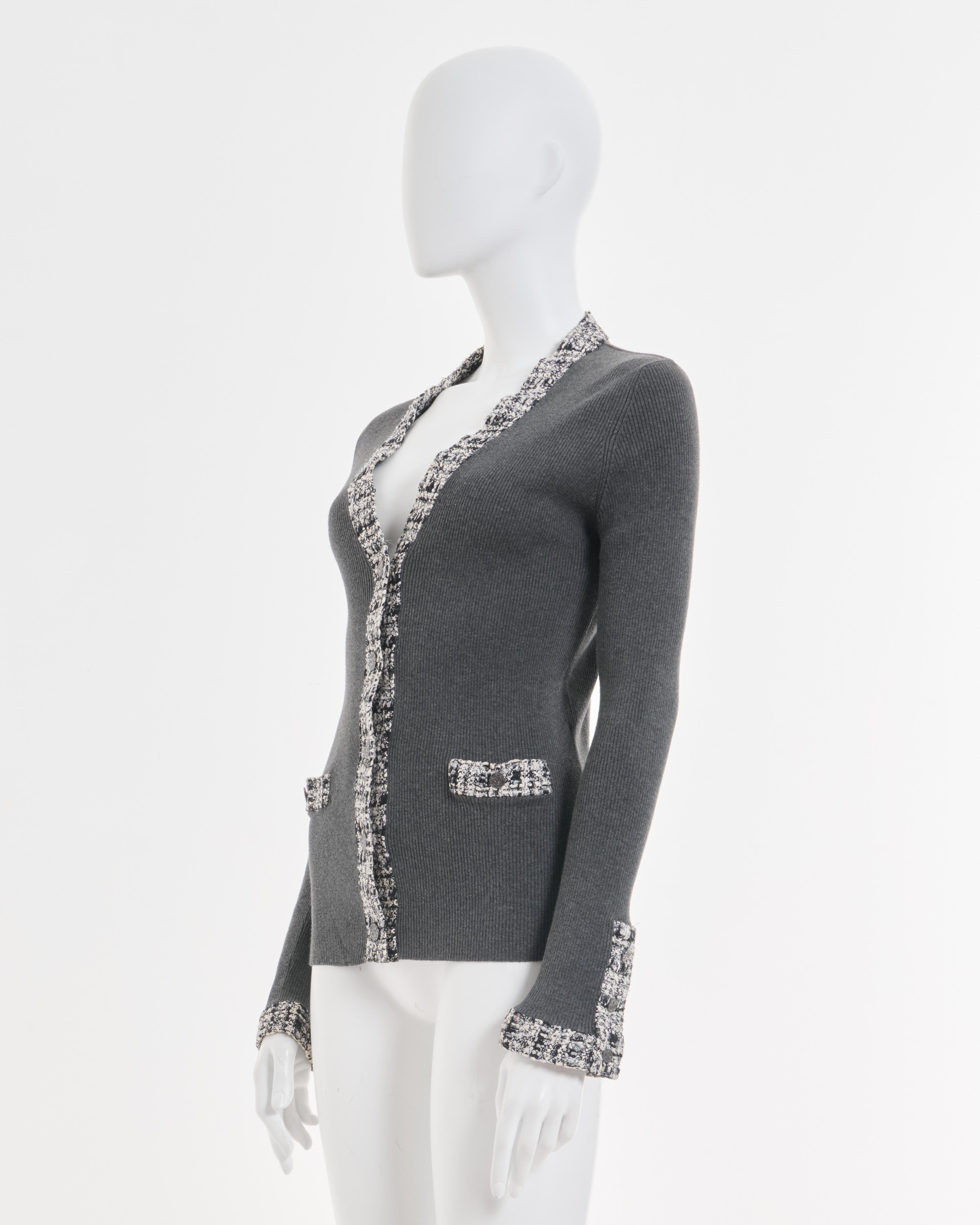 - Chanel - Cardigan en tweed de coton gris 
- Vendu par Skof.Archive
- Conçu par Karl Lagerfeld 
- Printemps-été 2004 
- Gris classique garni de franges multicolores
- Logo CC sur les boutons argentés 
- Décolleté en V 
- Fabriqué en Italie 
-