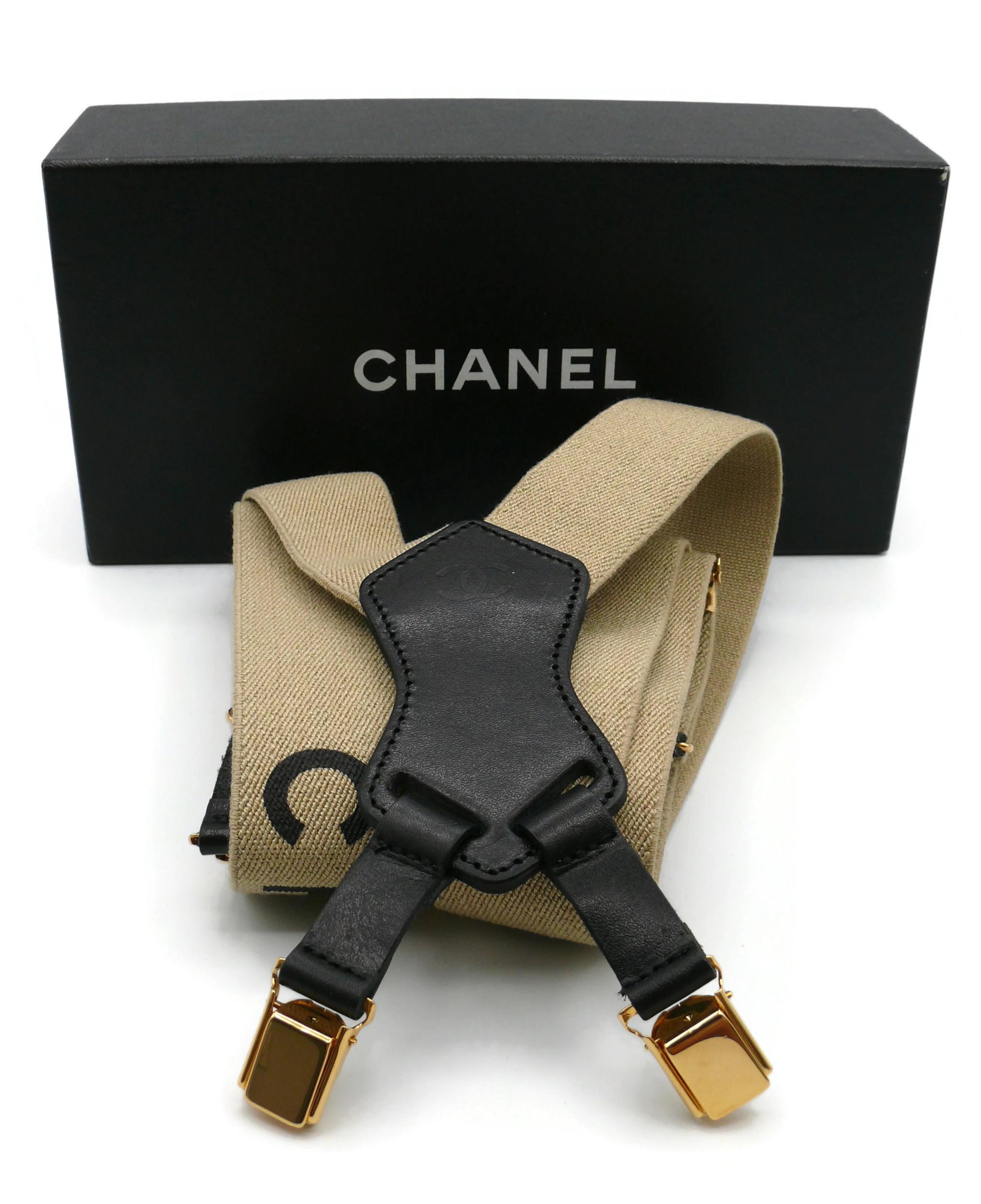 CHANEL by KARL LAGERFELD vintage Spring/Summer 1994 iconic rare suspenders in light brown version with black printed lettering, gold toned hardware and leather trim.

One size fits all (adjustable length).

CC logo embossed on the leather.

Label