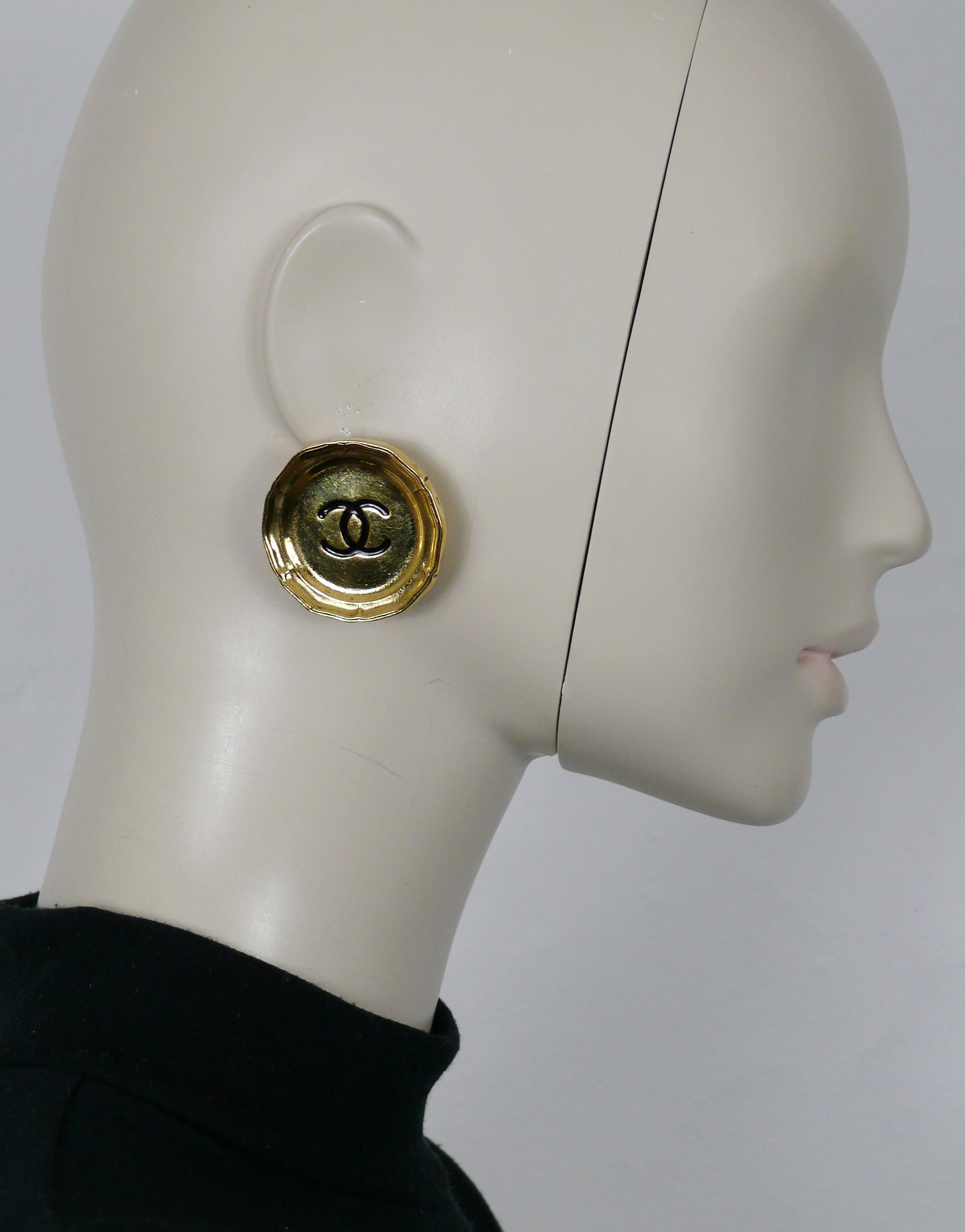 CHANEL by KARL LAGERFELD Vintage-Ohrringe in massivem Goldton in Form eines Tellers mit schwarzen CC-Logos in der Mitte.

Collection'S Nr. 24 (Jahr 1989).
Kreativdirektor für Schmuck : VICTOIRE DE CASTELLANE.

Geprägtes CHANEL 2 4 Made in
