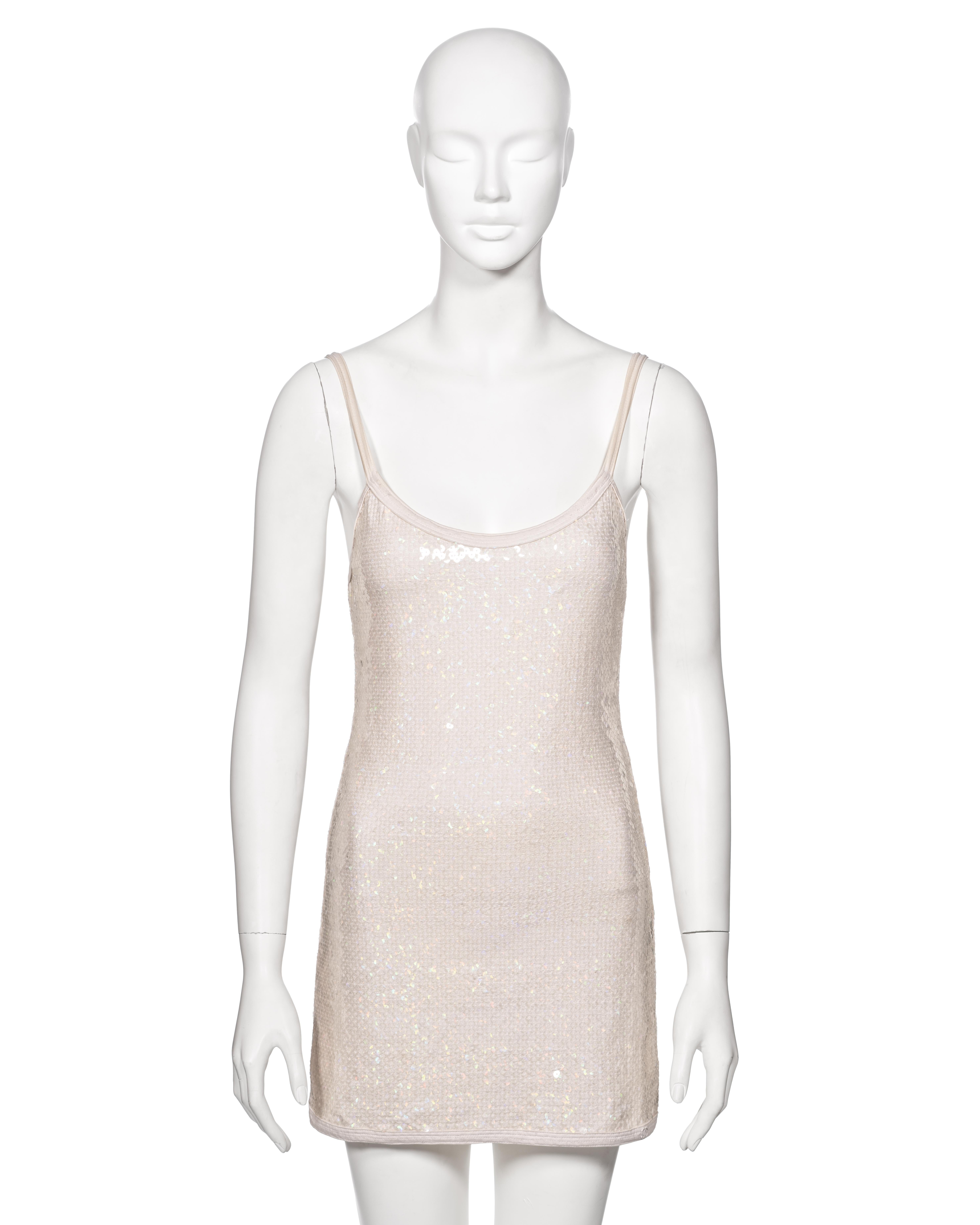 ▪ Chanel White Sequin Mini Dress
▪ Creative Director: Karl Lagerfeld 
▪ Spring-Summer 2005
▪ Sold by One of a Kind Archive
▪ Fashioned from white stretch lycra, embellished with clear iridescent sequins
▪ Features a classic scoop neckline paired