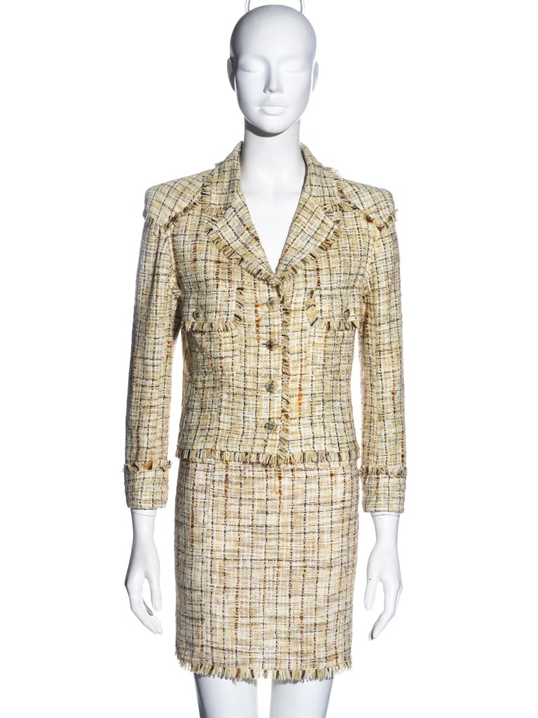 ▪ Chanel skirt suit 
▪ Designed by Karl Lagerfeld
▪ Sorbet yellow tweed with white, orange and grey 
▪ Single breasted jacket 
▪ Knee-length pencil skirt 
▪ Clear buttons with incased tweed and 'CC' logo 
▪ Shoulder pads 
▪ Frayed tweed trim 
▪