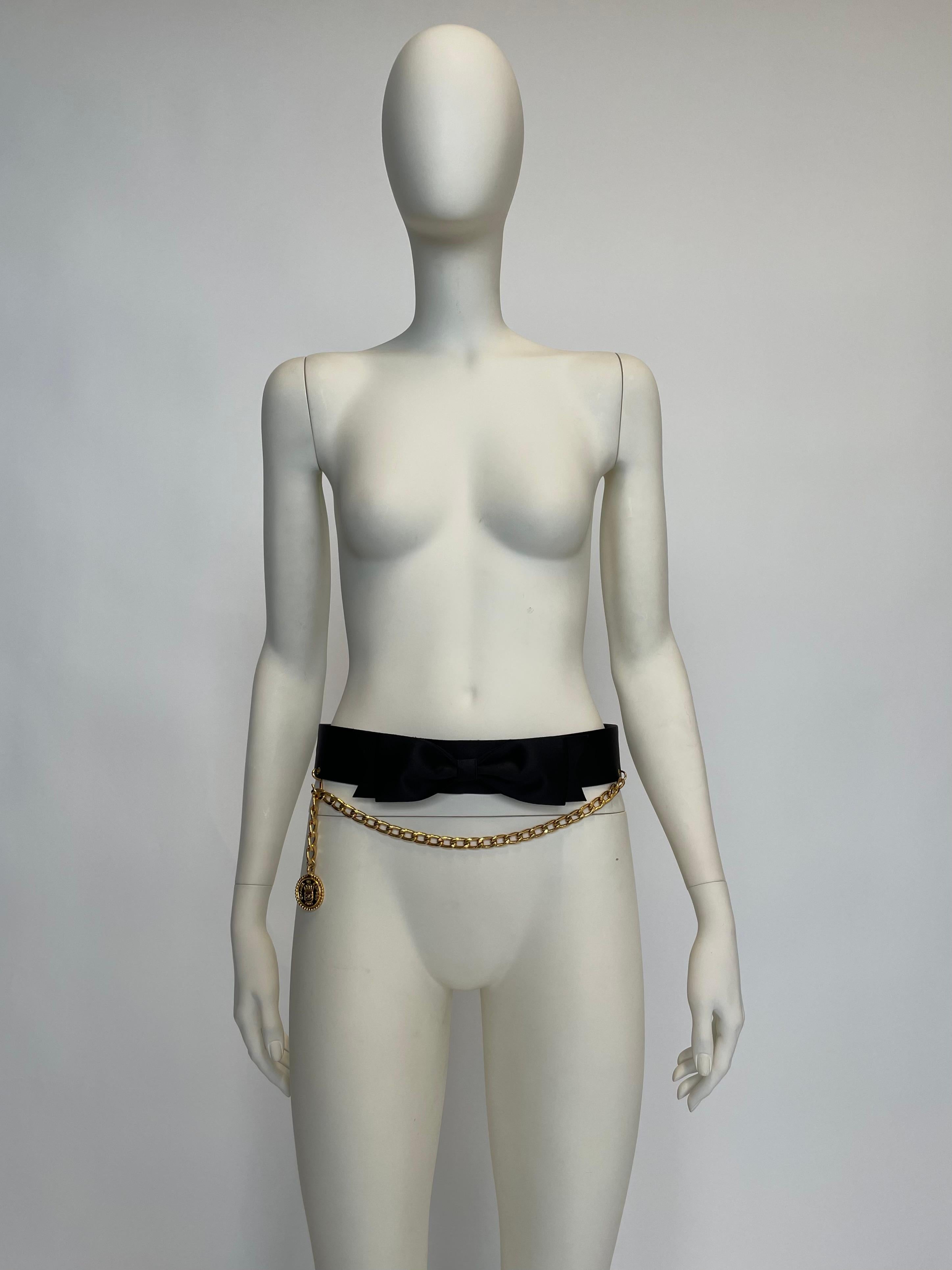 A fantastic “noughties” Chanel piece, this timeless waist belt will instantly elevate any outfit, for example by cinching the waist of an oversized blazer or dress. Crafted from black silk and smooth leatherette with gold-tone link chain and
