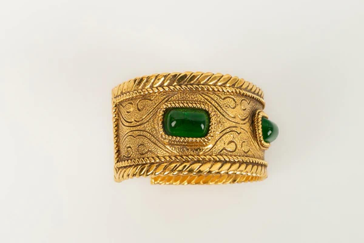 Chanel - (Made in France) Bracelet in gilded metal and cabochons in green glass paste. Collection 1985.

Additional information:
Dimensions: Circumference: 14.5 cm 
Opening: 3.5 cm 
Width: 3.5 cm
Condition: Very good condition
Seller Ref number: