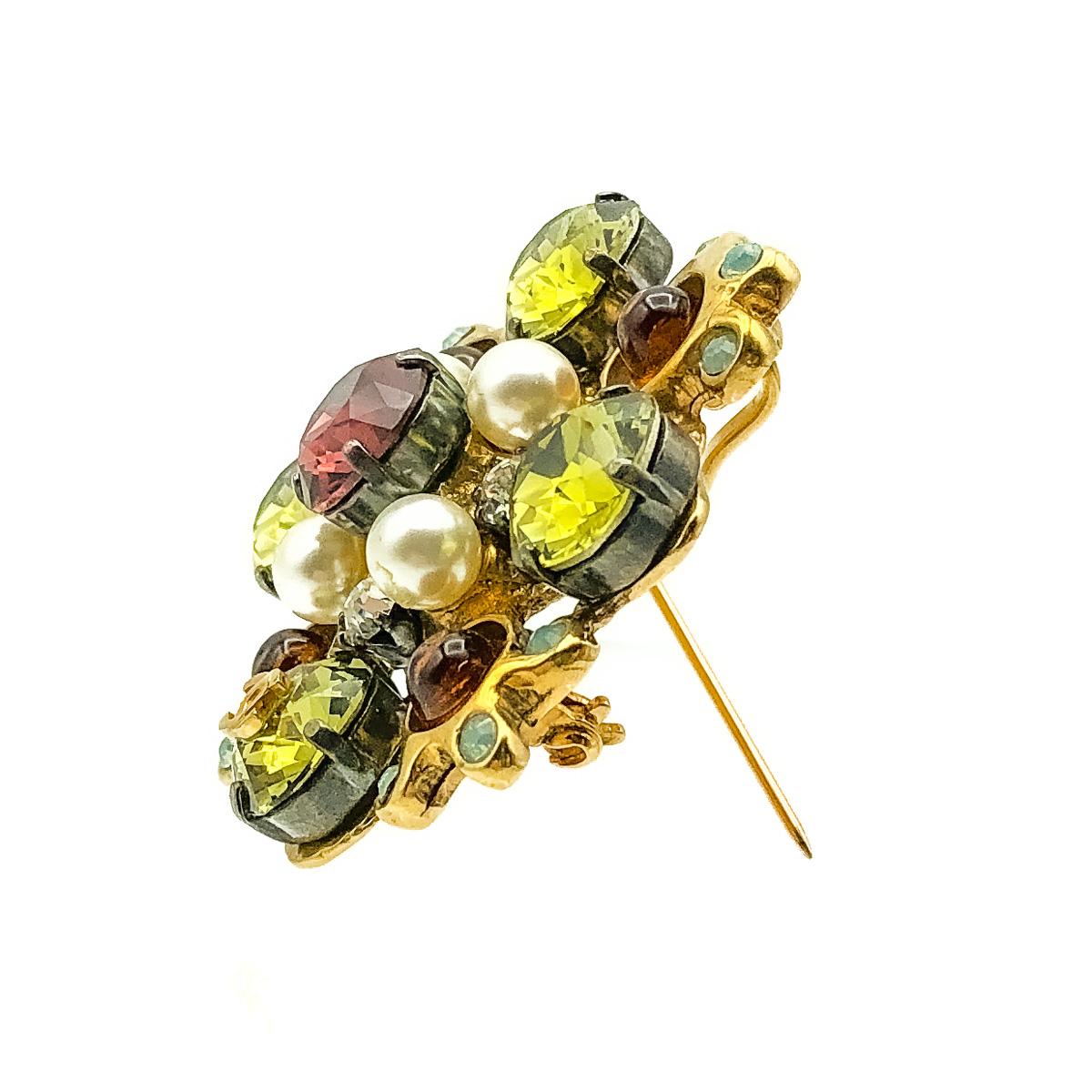 A beautiful Chanel Crystal Brooch from 2005.Designed in a Byzantine style. Featuring four large green faceted crystals interspersed with an equally impressive array of stones. Including whole faux pearls, burnt orange poured glass stones, white