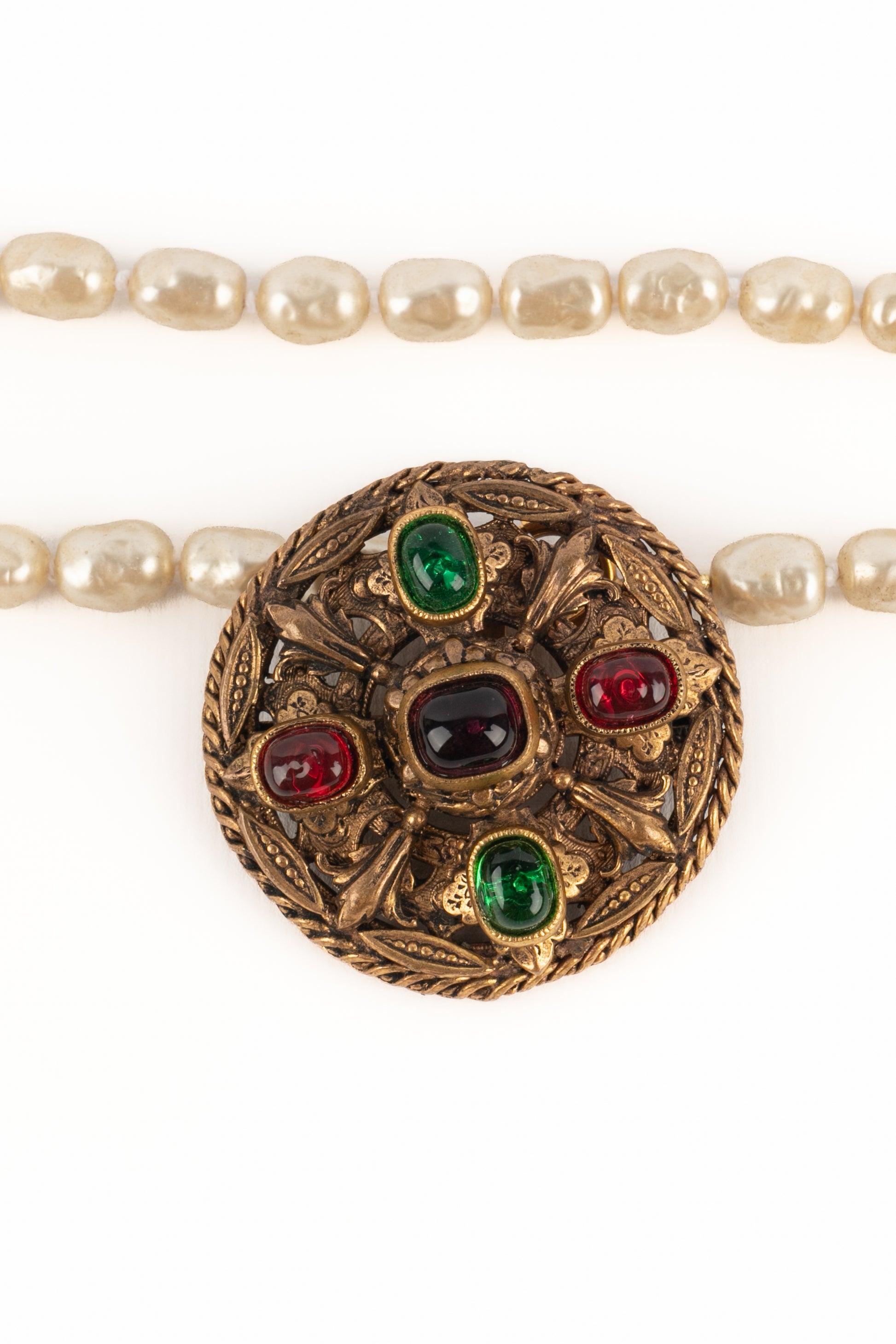 CHANEL - (Fabriqué en France) Collier de perles fantaisie avec médaillon byzantin en métal doré et cabochons en pâte de verre colorée. A 1983 Collectional.

Informations complémentaires :
Condit : Très bon état.
Dimensions : Longueur : 100 cm -