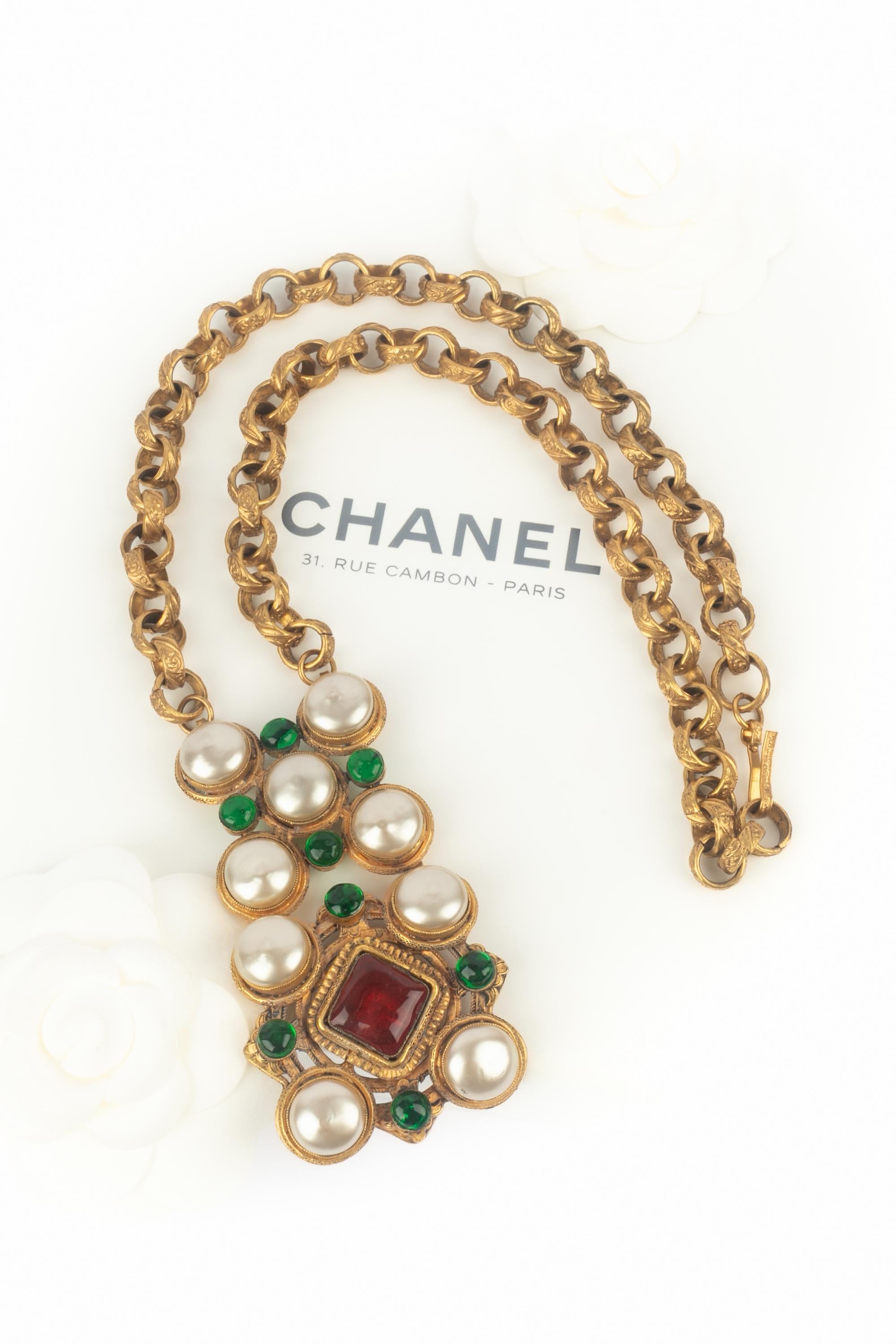 CHANEL - (Fabriqué en France) Collier pendentif en métal doré avec cabochons nacrés, et pâte de verre rouge et verte. Bijoux des années 1980.

Condit :
Très bon état.

Dimensions :
Longueur : 62 cm - Pendentif : 9 cm x 4 cm

SKU:CB261