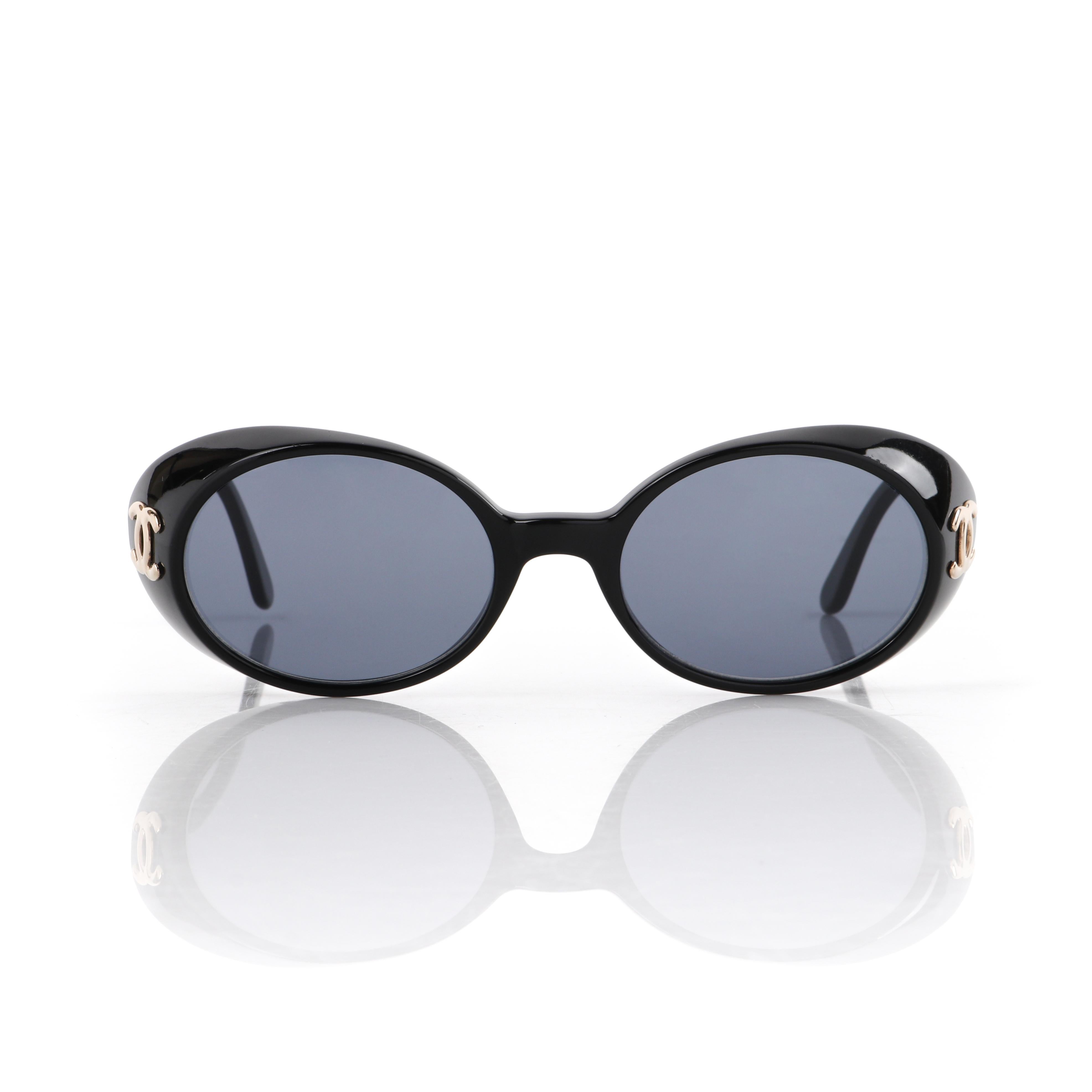 CHANEL c.1990's Gafas de sol ovaladas negras Logo CC dorado de plástico 05976 c/Caja
 
Marca/Fabricante: Chanel
Circa: años 90
Diseñador: Karl Lagerfeld
Estilo Gafas de sol ovaladas 
Color(es): negro, dorado 
Forrado: No
Sin marcar Materiales