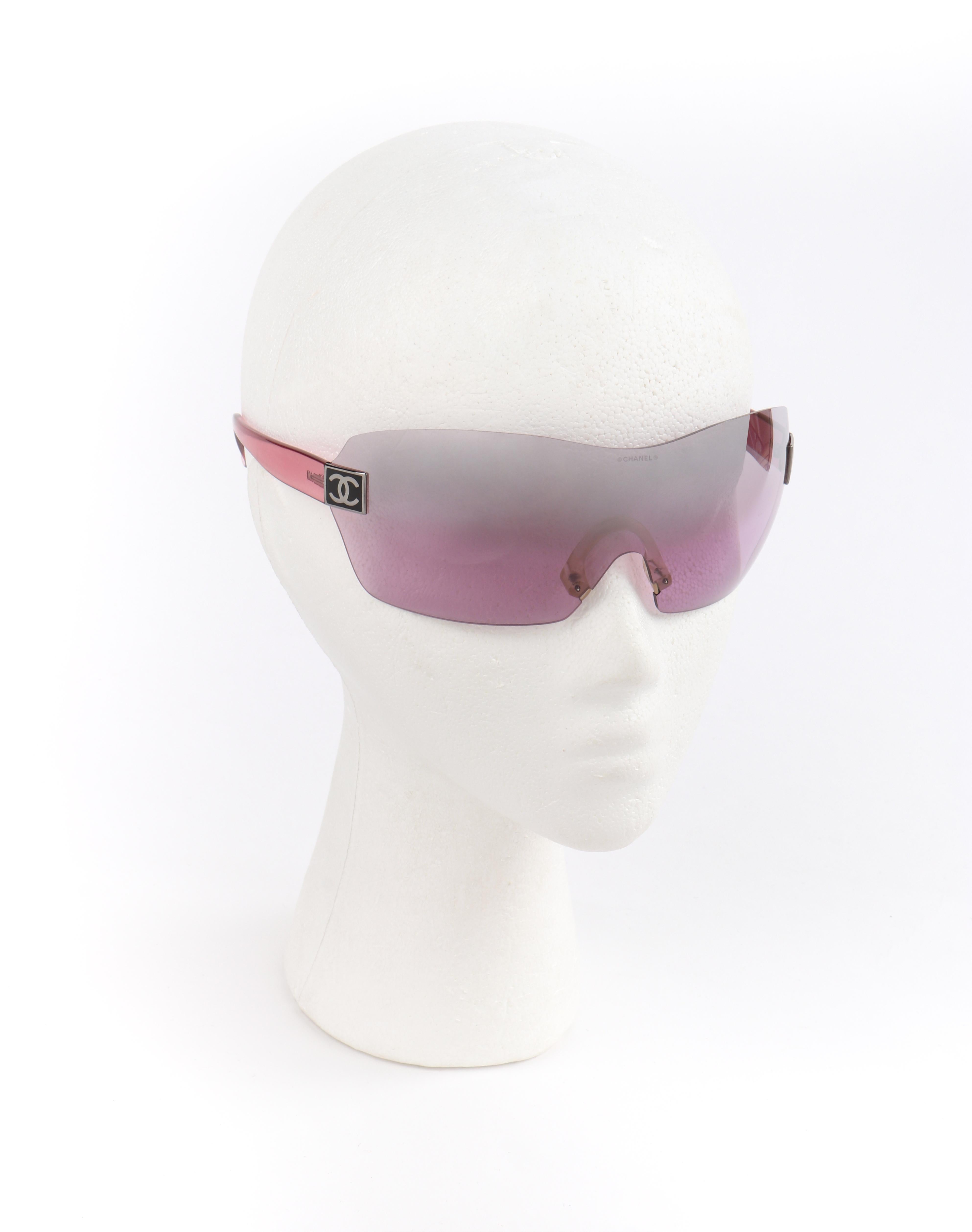 CHANEL c.2000’s Pink Translucent CC Logo Shield Rimless Sunglasses 4111 w/Box
 
Brand/Manufacturer: Chanel
Circa: 2000’s
Designer: Karl Lagerfeld
Style: Rimless shield sunglasses
Color(s): Shades of pink, black, silver
Lined: No
Unmarked Fabric