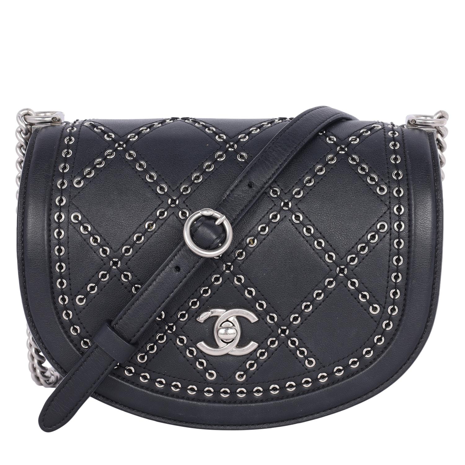 Authentic, pre-owned Chanel black calfskin leather Coco Eyelet Flap cross body bag. Features black leather with silver hardware, a long black and silver chain strap, a turn lock front flap top closure with CC on the under flap, diamond pattern made