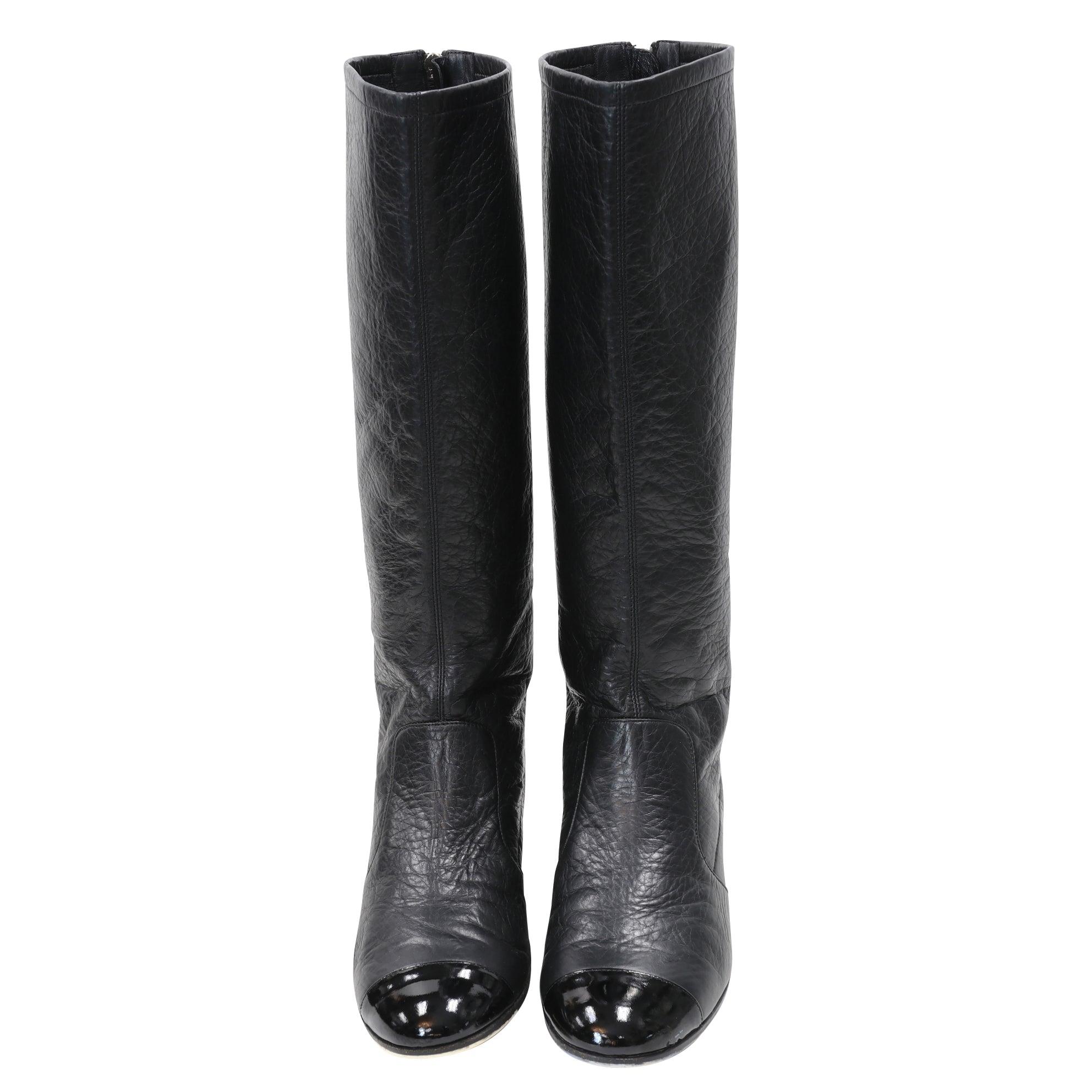 These Classic Chanel boots are a timeless piece. Made from calfskin leather, these boots feature a cap toe black gloss tone with a modern detail and a block heel. Leather lined uppers make for a comfortable fit. These boots are completely attention