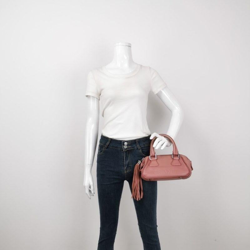 CHANEL Calfskin Leather Tassel Small Pink Bowler Bag Ce sont des photos professionnelles du sac offert par Luxbags. Il s'agit d'un authentique petit sac bowler CHANEL en Caviar Patent Quilted, de couleur rose rare. Elegamment confectionné en cuir de