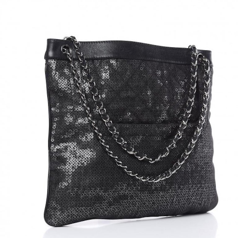 This super-chic limited edition Chanel tote bag is from 2009 and is crafted of hidden silver sequin-enclosed black mesh fabric and leather. The bag features the archetypical black leather and silver chain strap and is emblazoned to the front with a