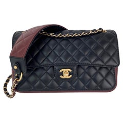Chanel in pelle di vitello con tracolla trapuntata e patta in nero e bordeaux