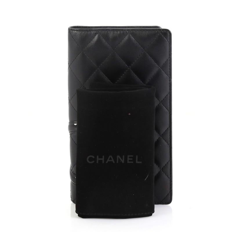 This Chanel Cambon Agenda Cover Quilted Lambskin, crafted from black lambskin leather, features patent leather Chanel CC logo patch and silver-tone hardware. It opens to a black leather interior with slip pockets. Hologram sticker reads: 12526072.