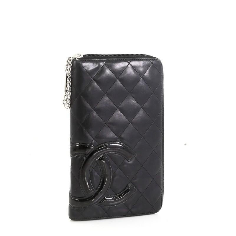This Chanel Cambon Zip Around Organizer Quilted Lambskin, crafted from black lambskin leather, features patent leather Chanel CC logo patch and silver-tone hardware. Its all around zip closures opens to a pink leather interior with multiple card