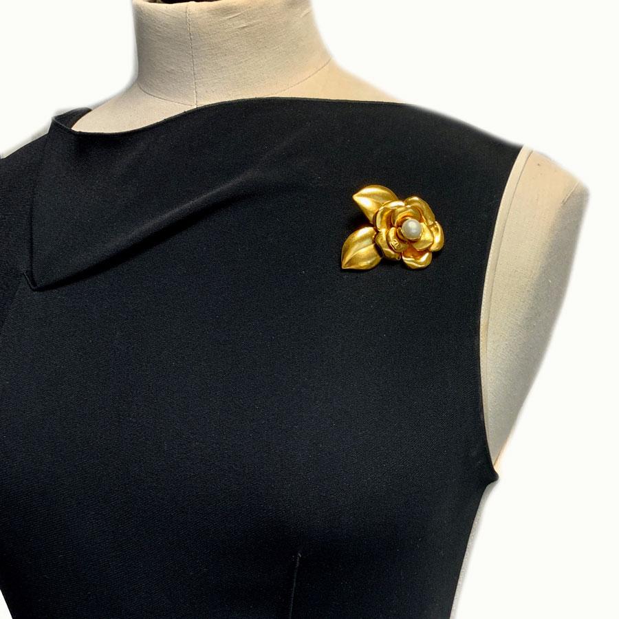 CHANEL Camellia brooch in gilt metal set with a pearly pearl. It is a vintage jewel, which, worn off-set will be in the trend.
In very good condition. Pearl mother-of-pearl peeling a little.
The stamp S is engraved on the back of the brooch.
There