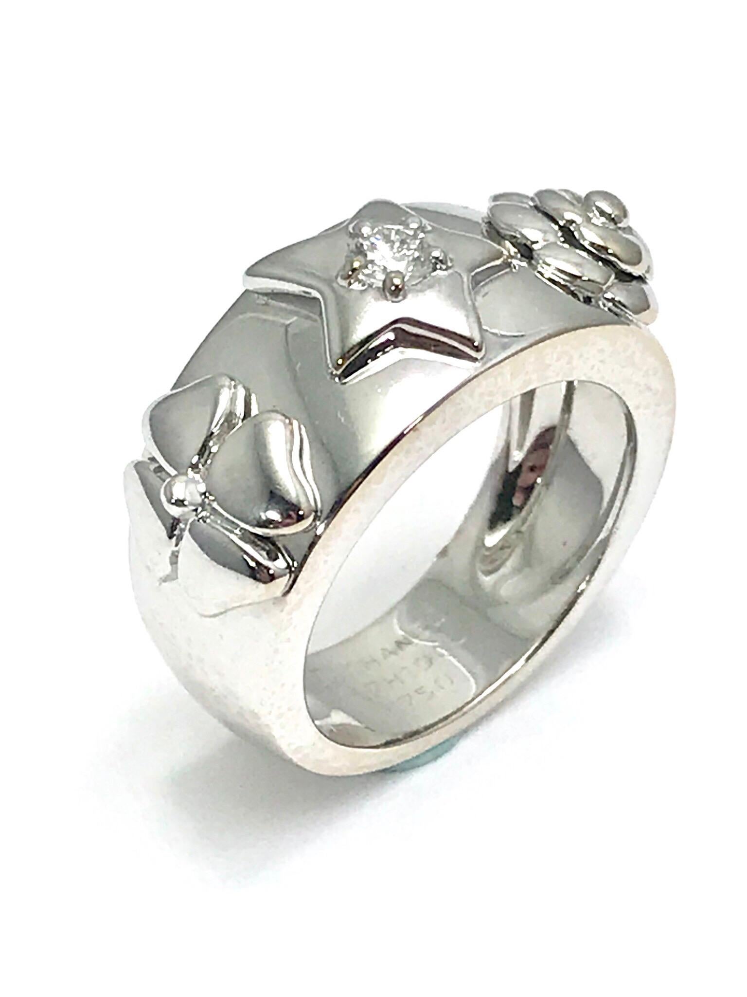 This is a great, easy to wear piece.  A Chanel Camelia Diamond star, flower and four leaf clover 18 karat white gold band ring.  The round brilliant diamond is set with five prongs, and weighs 0.10 carats,  graded as F color, VS1 clarity.  The ring