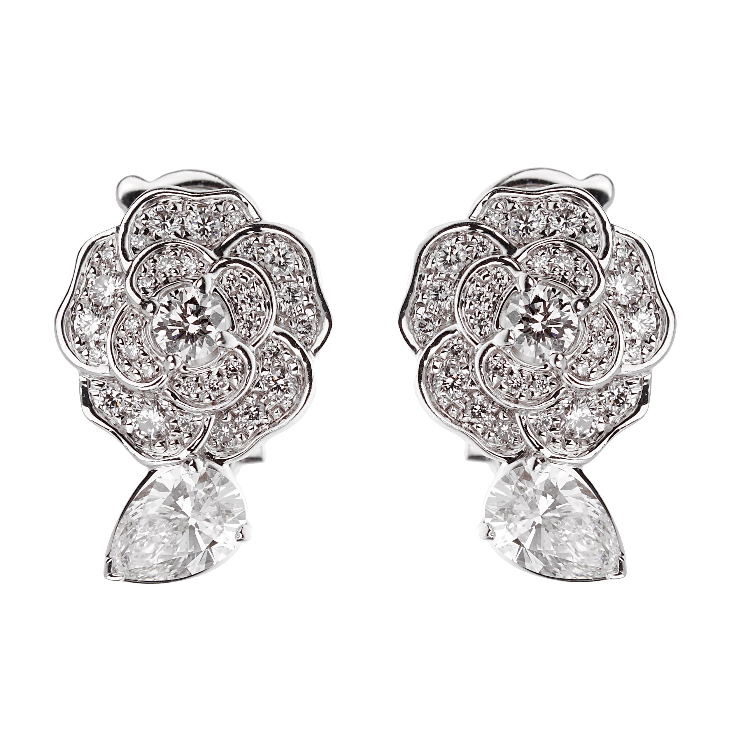 At the heart of these exquisite earrings are two pear-cut diamond center stones, each weighing 0.40 carats. Pear-cut diamonds, known for their unique combination of a round and marquise shape with a tapered point on one end, are celebrated for their