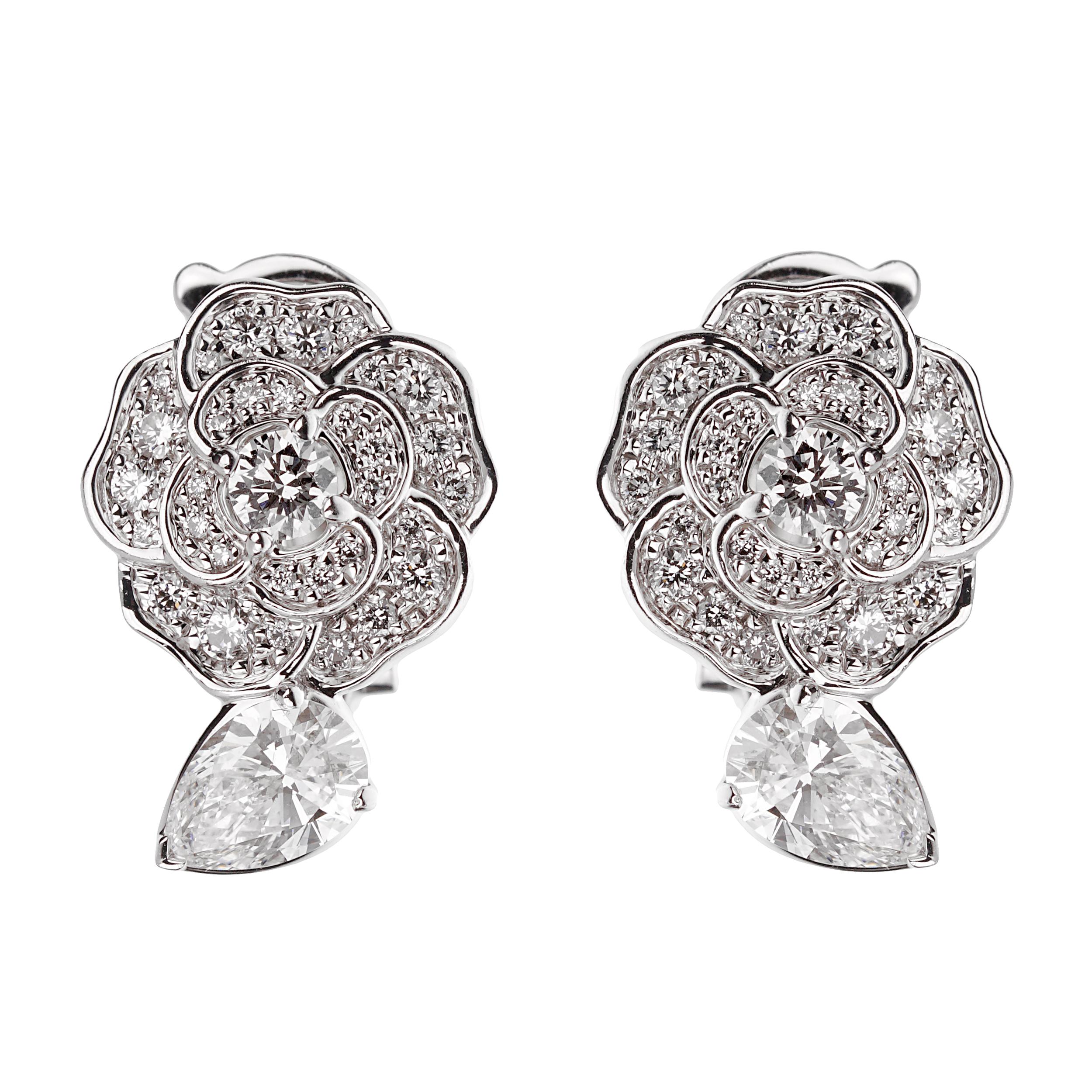 At the heart of these exquisite earrings are two pear-cut diamond center stones, each weighing 0.40 carats. Pear-cut diamonds, known for their unique combination of a round and marquise shape with a tapered point on one end, are celebrated for their