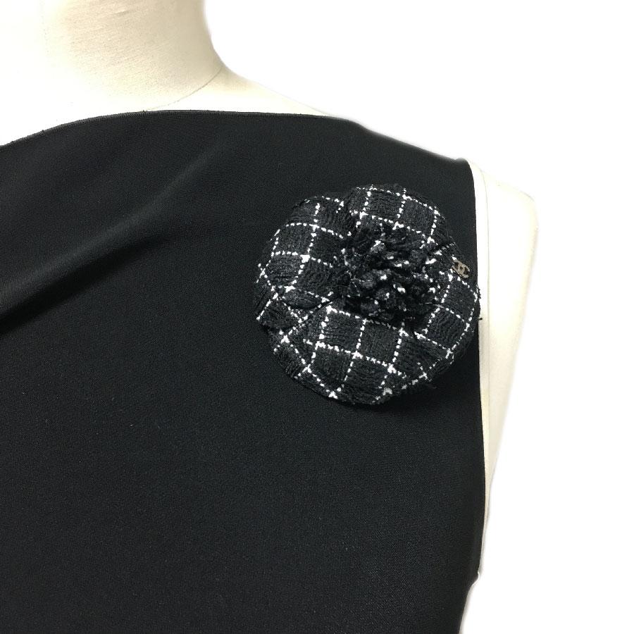 Camellia brooch from Maison CHANEL. It is in black tweed with white threads. A CC in silver metal is on the side. Embellish your coats, jackets, scarves or hat with this beautiful brooch.
It is in perfect condition. Never worn. There is no stamp of