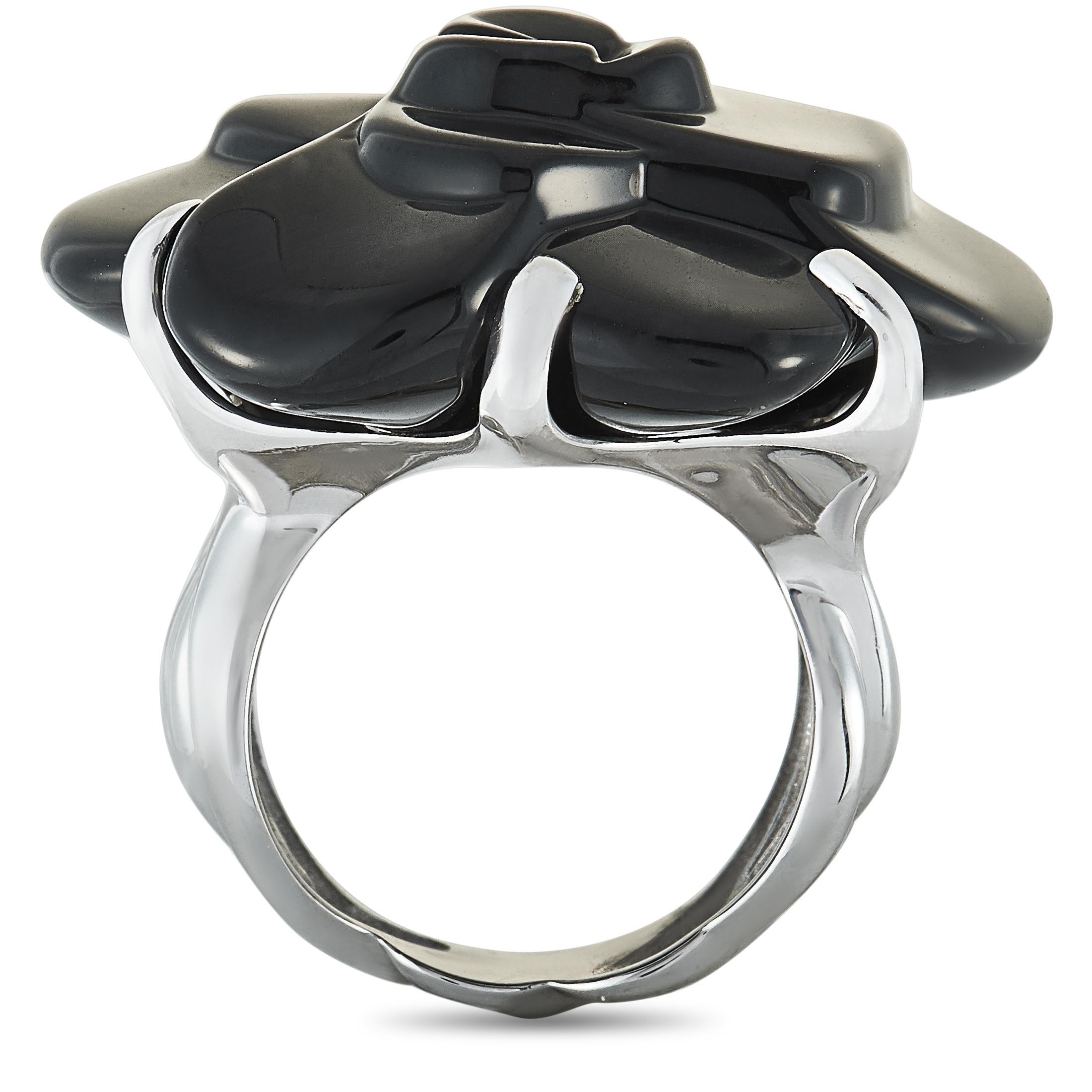 The Chanel “Camélia” ring is crafted from 18K white gold and set with an onyx. The ring weighs 21.6 grams, boasting band thickness of 7 mm and top height of 13 mm, while top dimensions measure 30 by 30 mm.

This jewelry piece is offered in estate